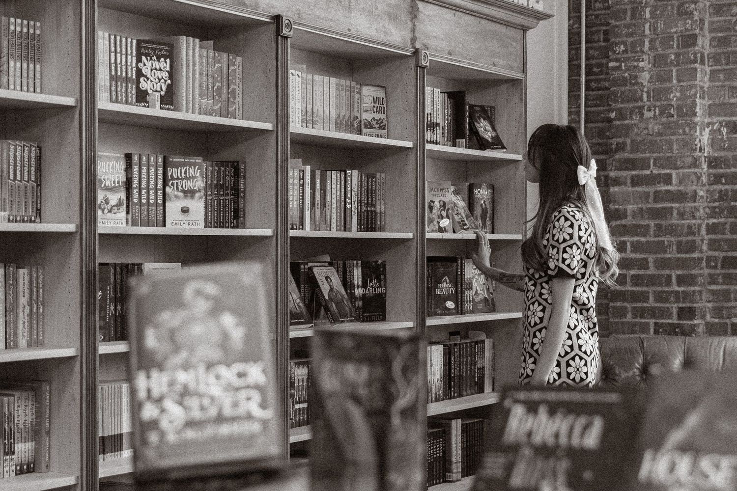 Row of bookshelves in a library with brick walls and wooden details.