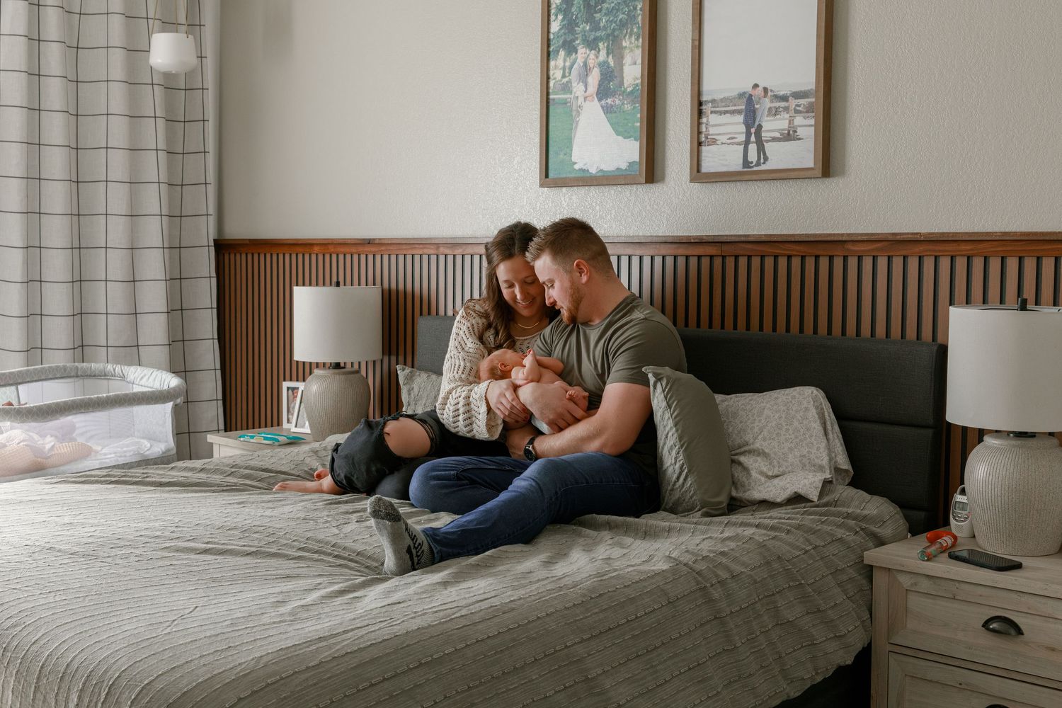 A series of framed photographs hanging above a bed in a modern bedroom.
