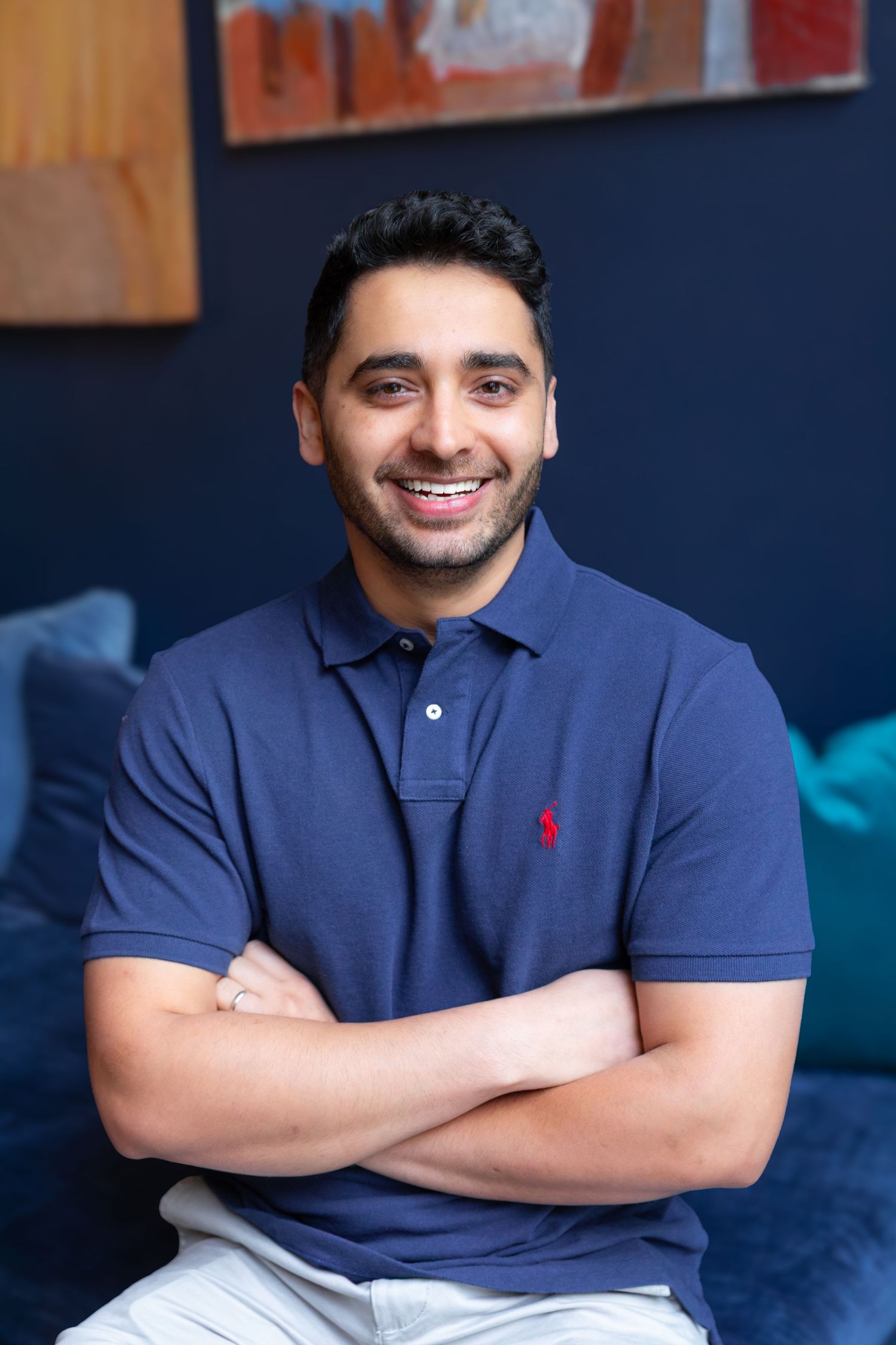 Professional headshot series showing confident poses in navy polo shirt.