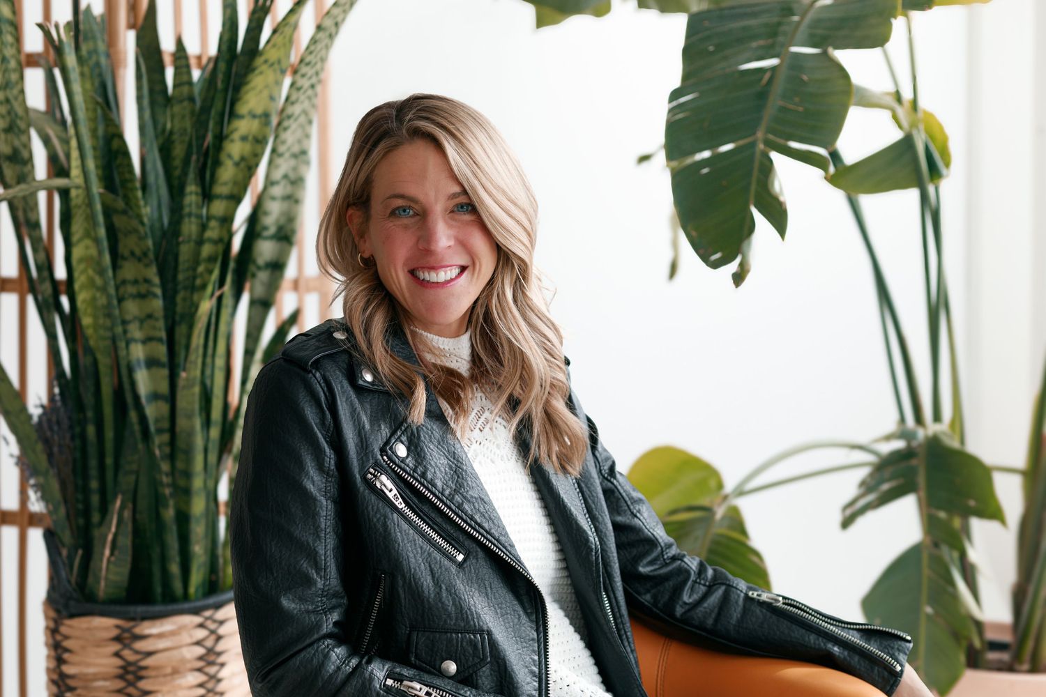 Indoor portrait series with leather jacket and houseplants in bright modern setting.