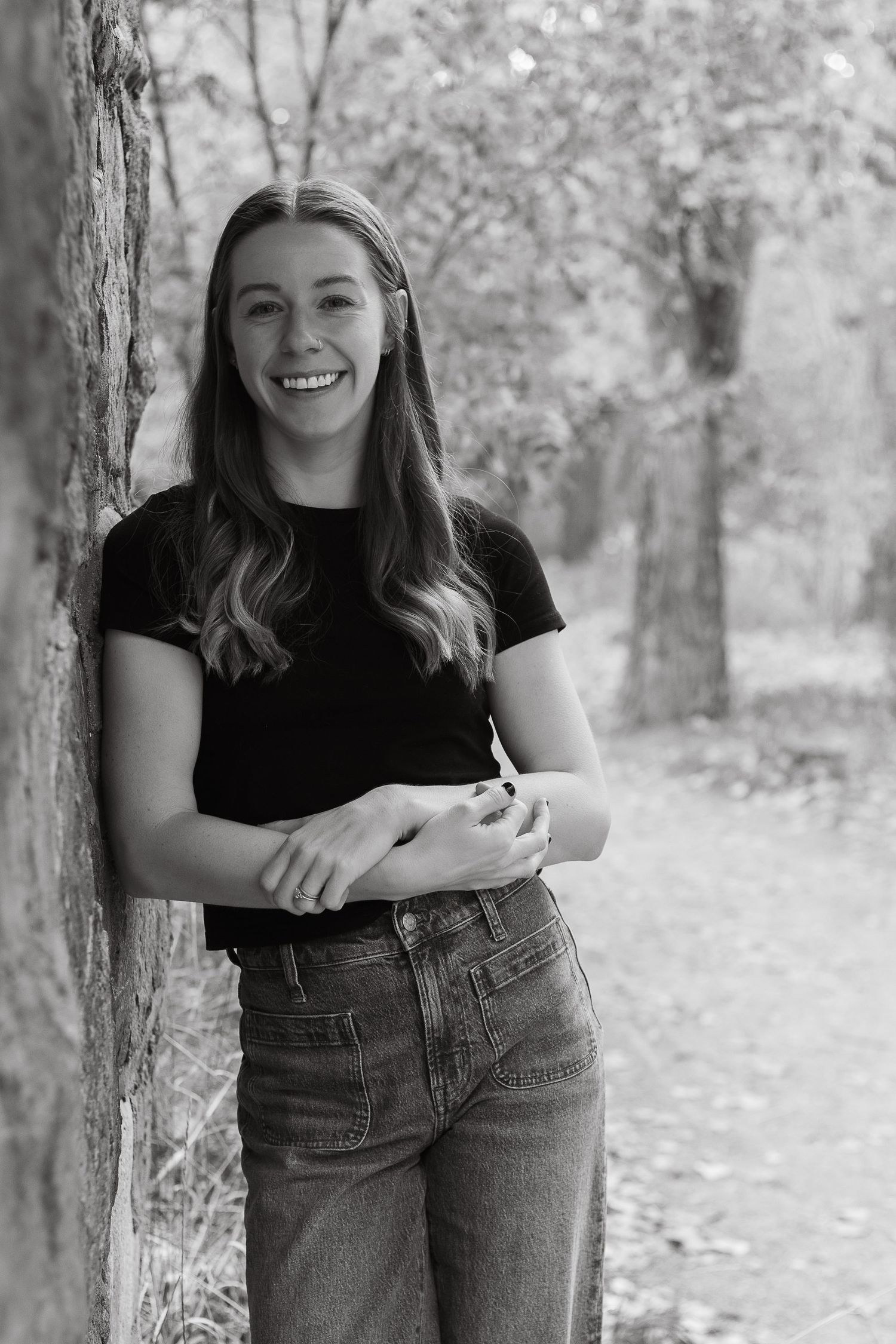 Black and white portrait series in autumn setting with fallen leaves and trees.