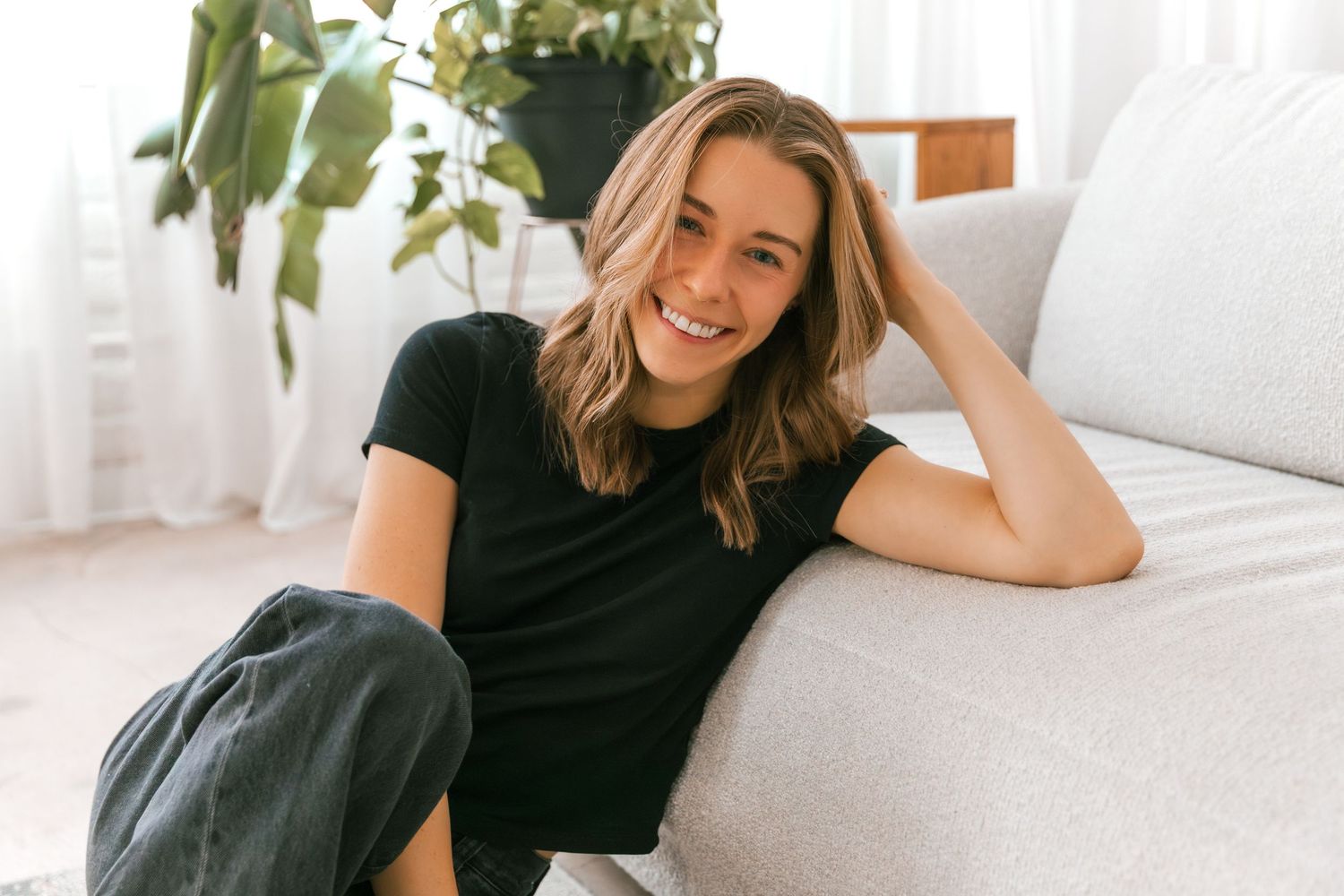 Lifestyle photography series showing casual poses on white couch with natural lighting.