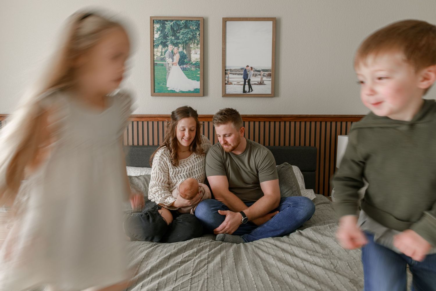 Family lifestyle photos taken on couch with wood paneled wall and framed art.