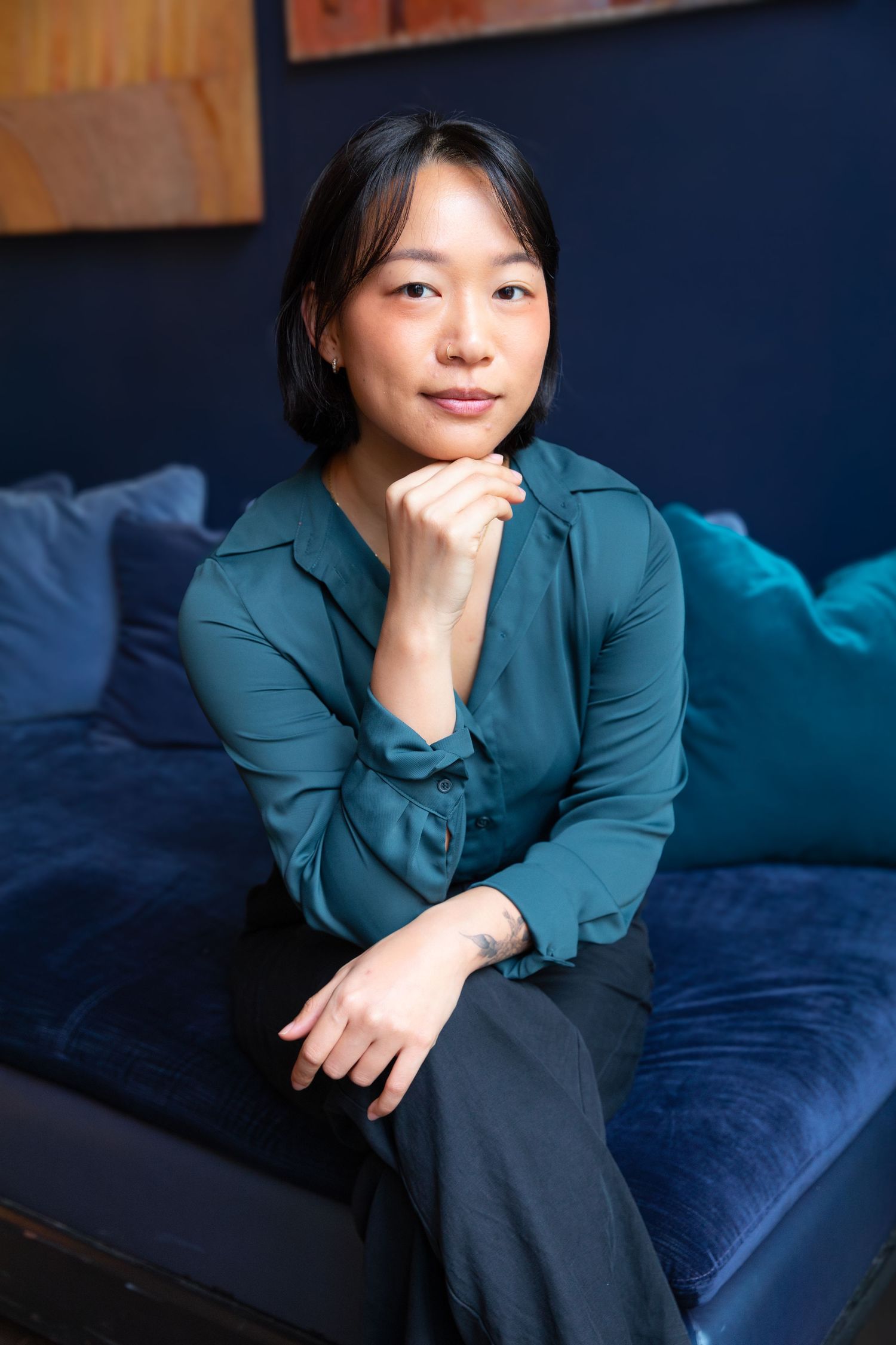 Casual portrait series in teal blouse against navy blue background.