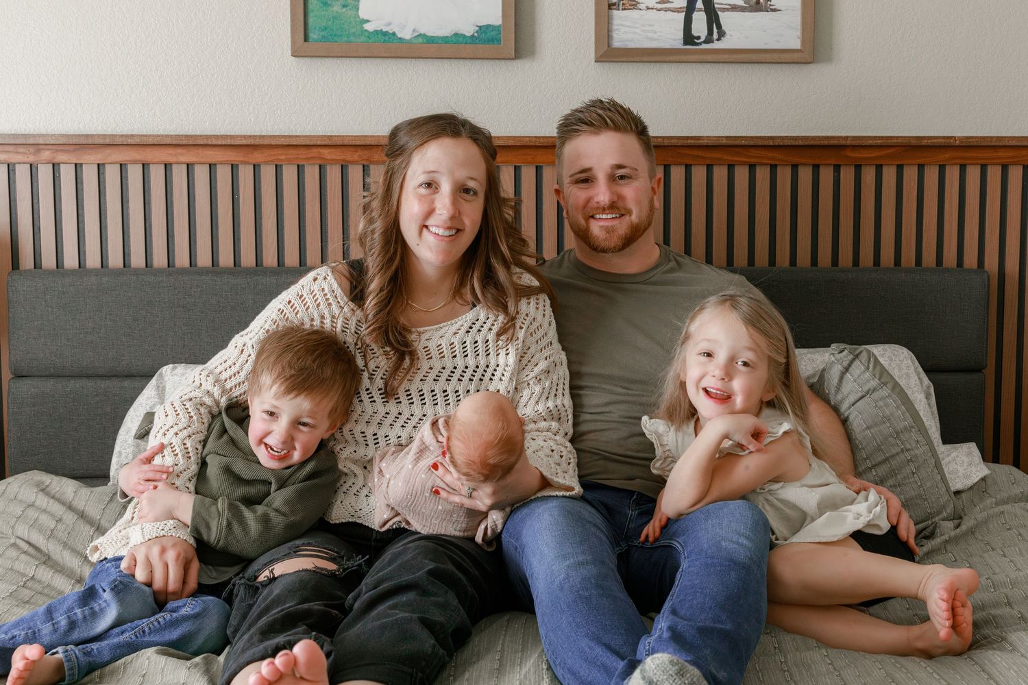 Candid family moments captured on a couch with natural lighting and framed artwork in background.