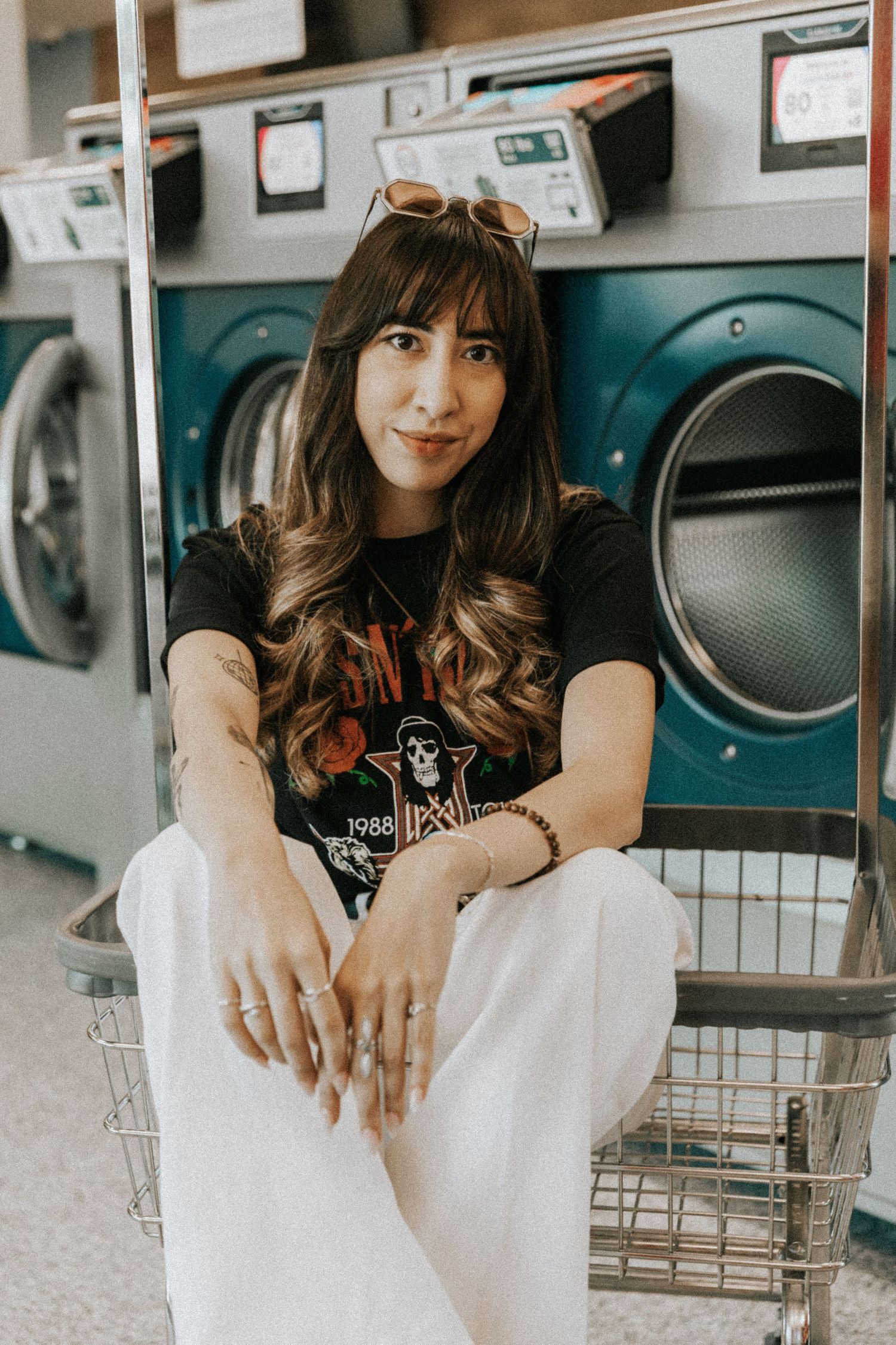 Casual portrait session at a laundromat with washing machines in background.