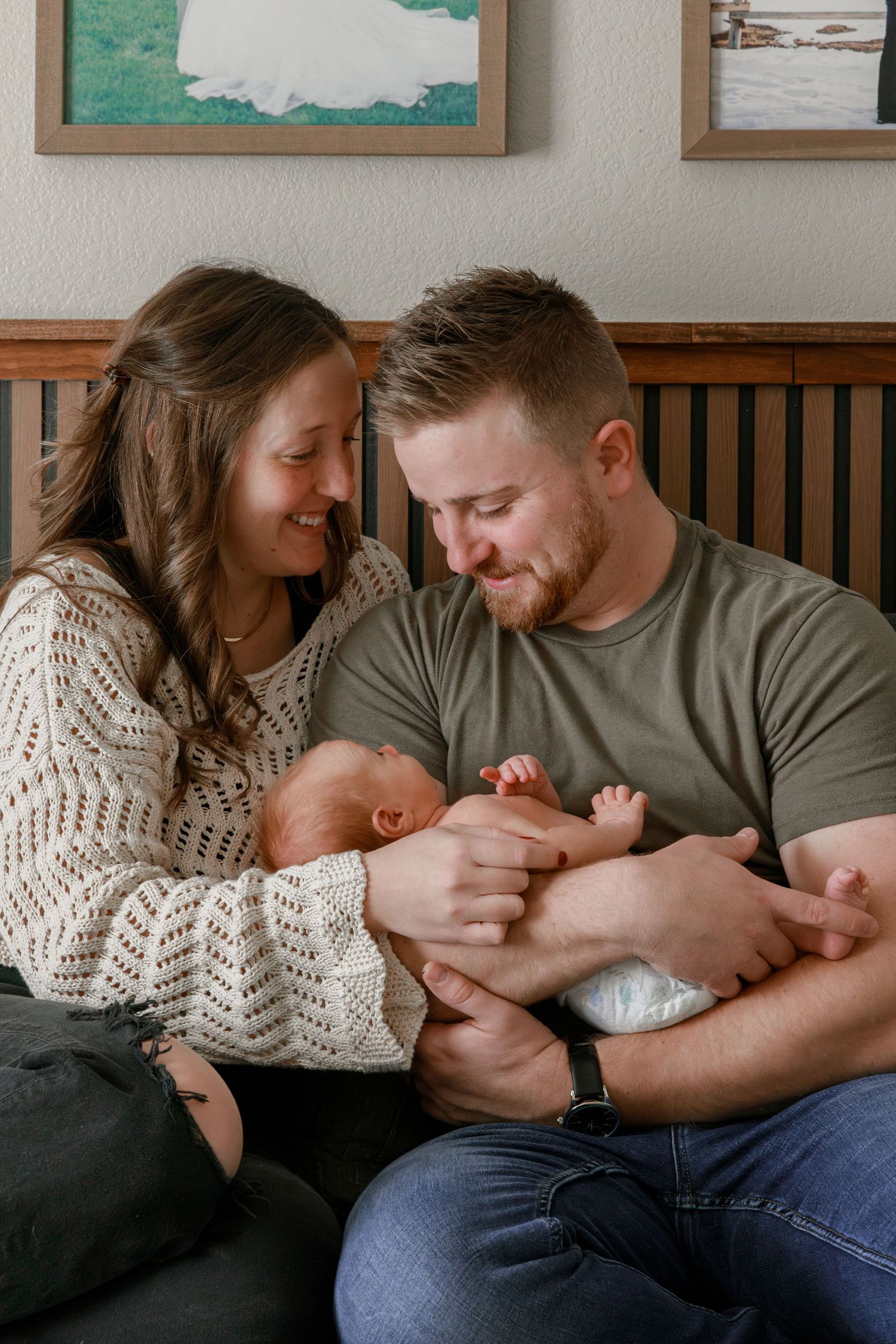 Family bonding moment photographed in natural light with wall art in background.