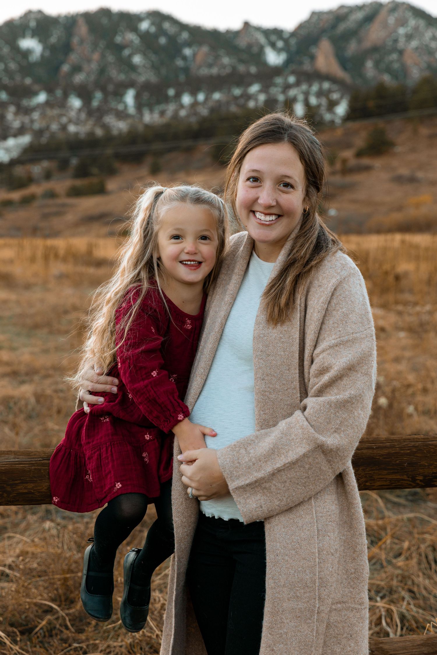Outdoor family portrait with autumn mountains in background during golden hour.