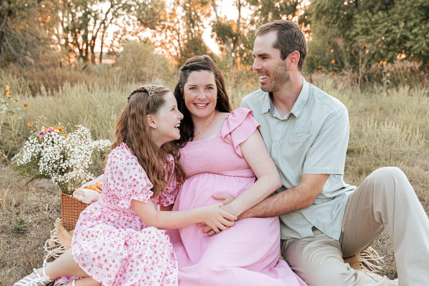 A couple shares intimate moments during an outdoor maternity photoshoot.