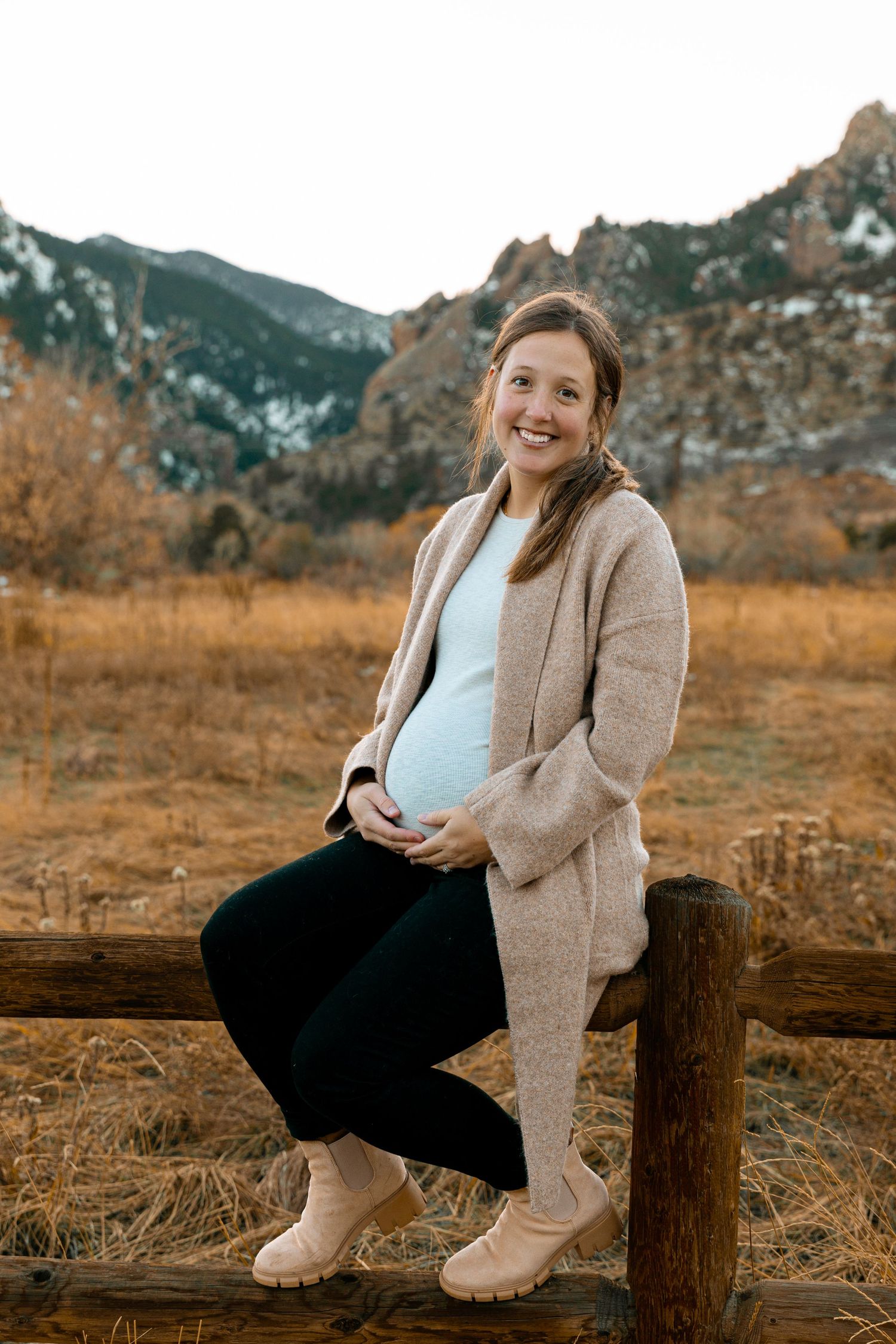 A maternity photo in a scenic mountain landscape during autumn.
