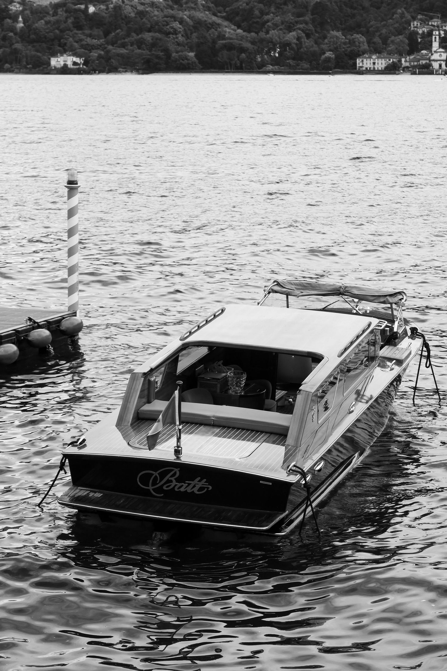 Vintage wooden boat partially submerged in lake water shown in black and white photography.