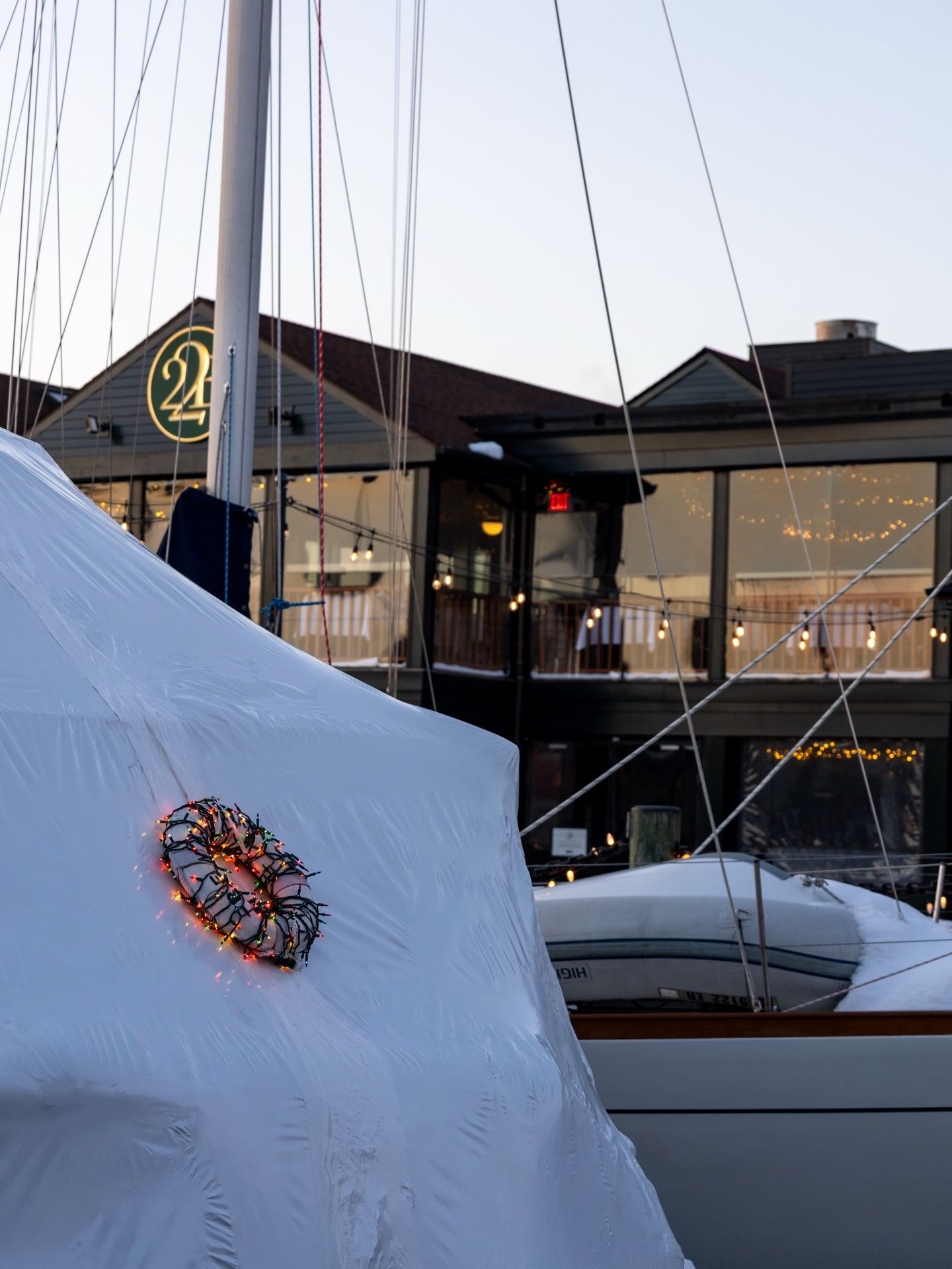A sequence of photos showing a colorful butterfly decoration on a white boat sail against a dark background.