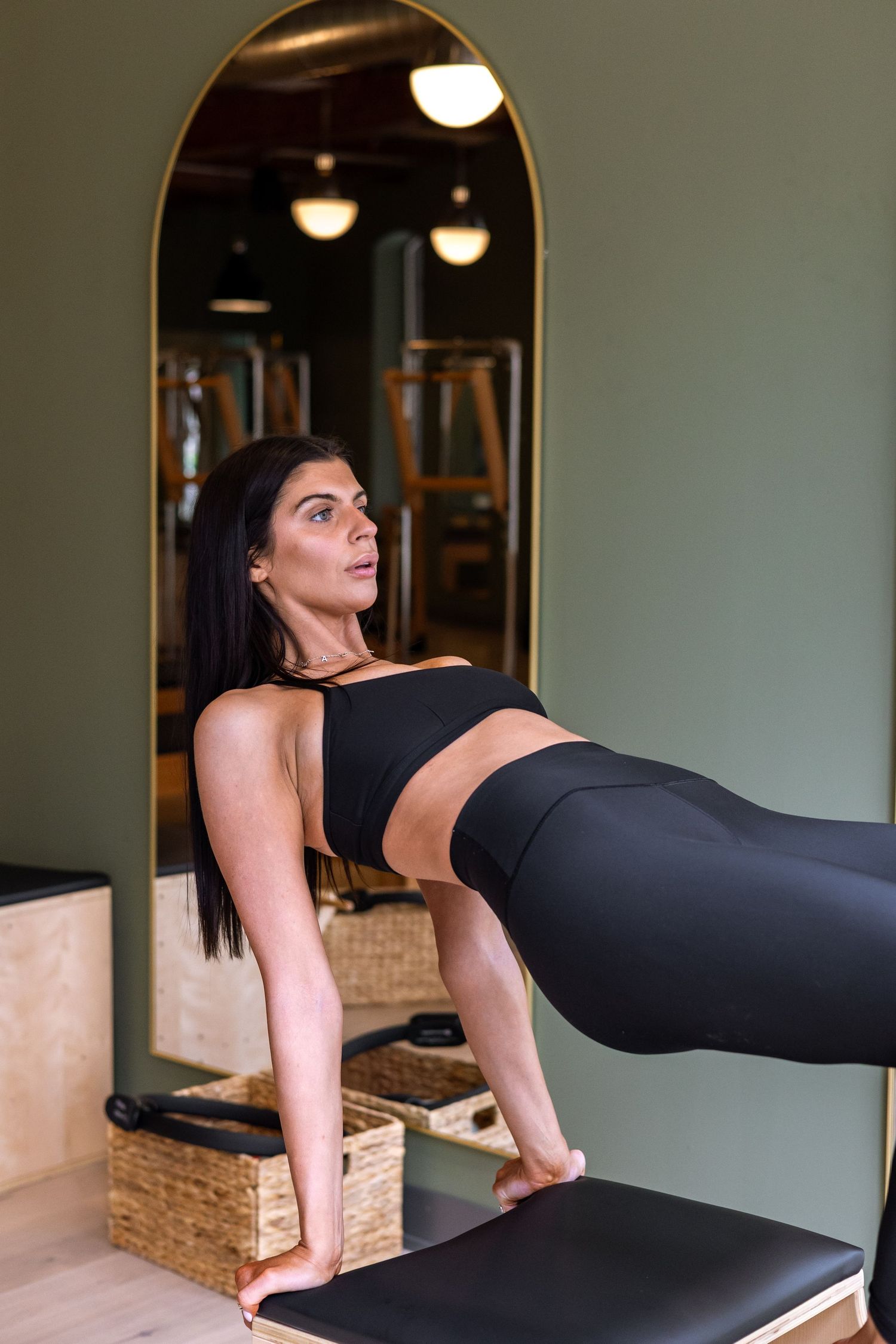 Side view of Pilates reformer exercise demonstrating core strength and balance.