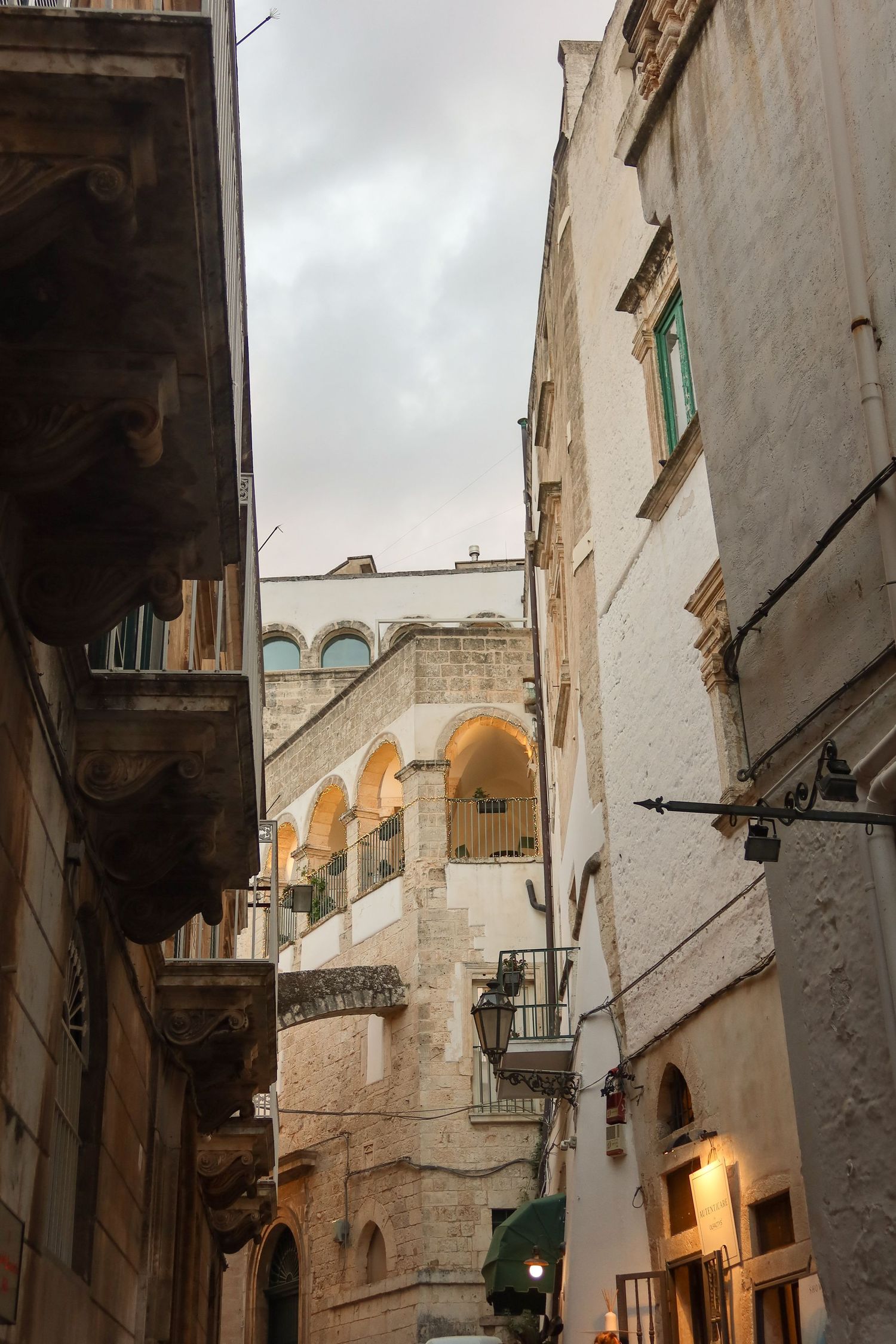 Historic stone alleyway with arches and traditional architecture lit by warm evening light.