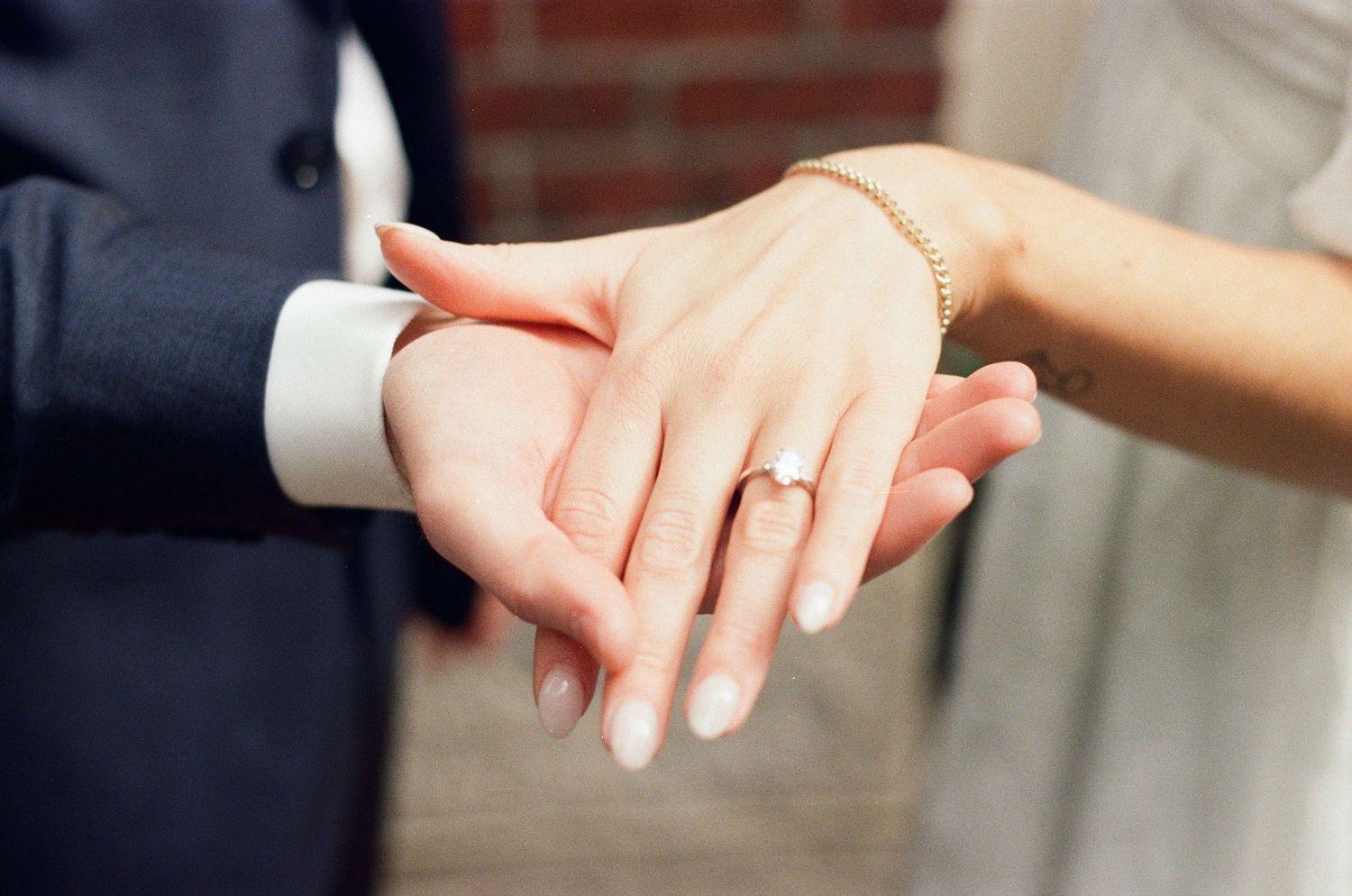 A sequence of hands reaching out to touch each other against a blurred background.