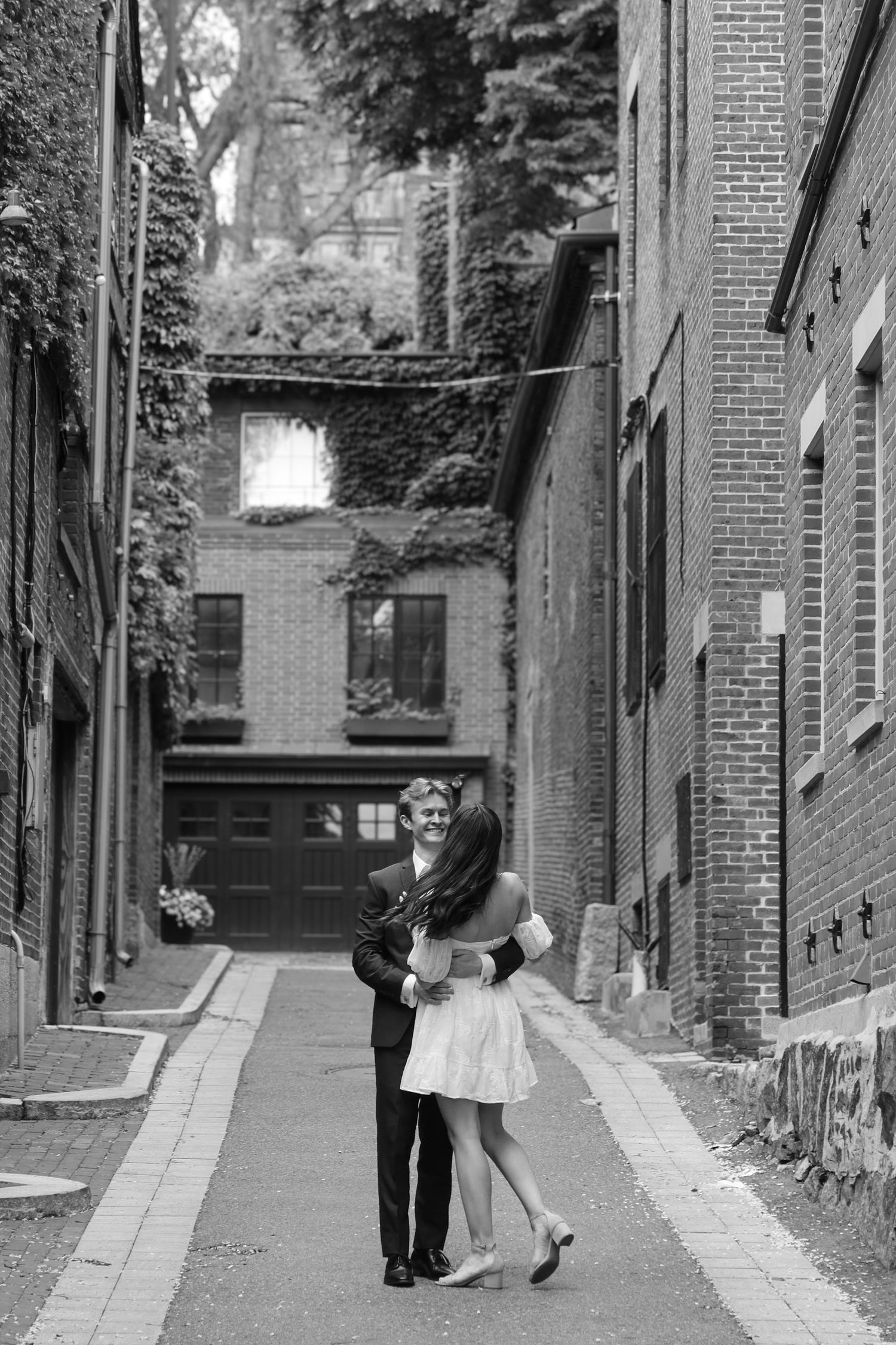 A romantic dance sequence photographed in an urban alley with brick architecture.