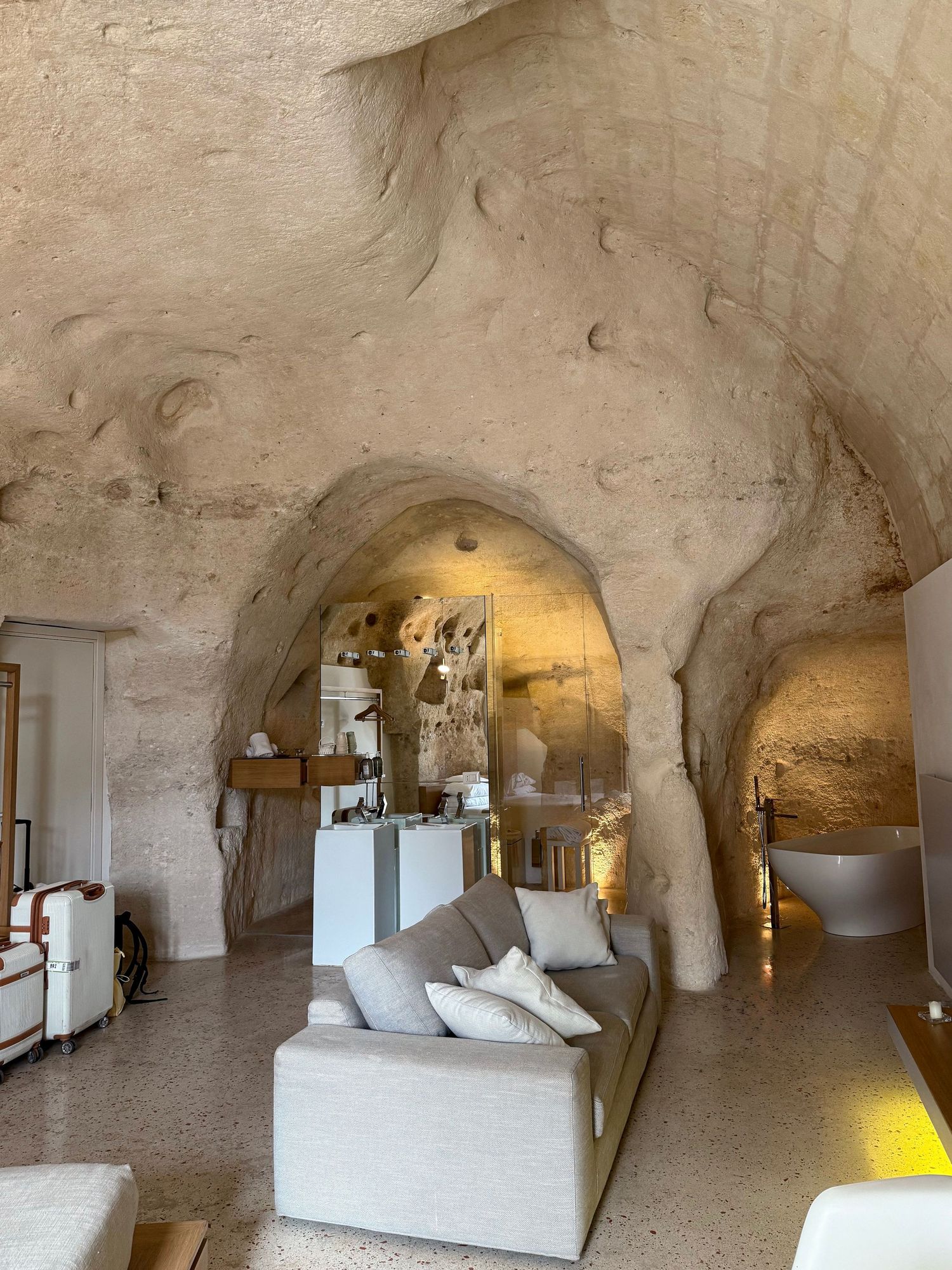 A contemporary living space within cave walls featuring modern furniture and atmospheric lighting.