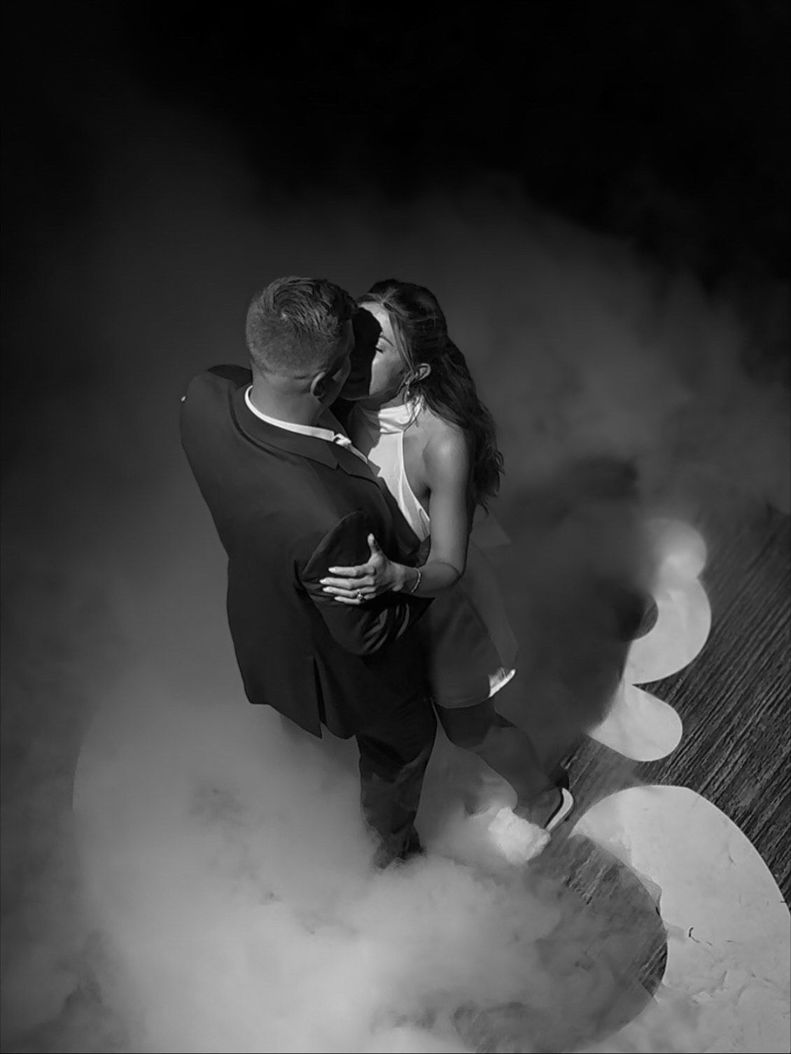 Contemporary dancers performing an expressive duet in moody black and white lighting.