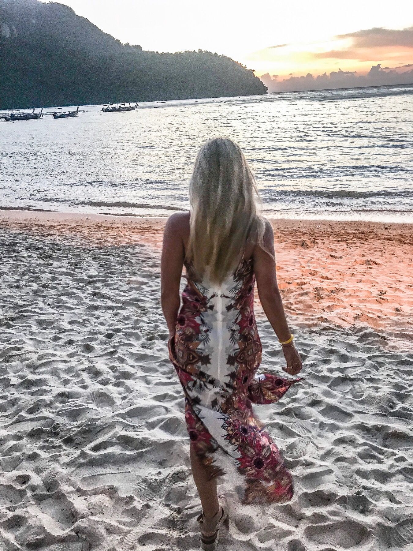 A series of sunset beach photos showing someone sitting on sandy shores with mountains and ocean views at dusk.