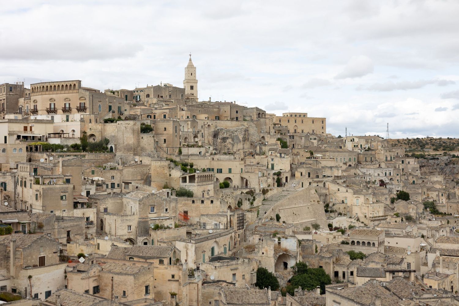 Panoramic view of ancient stone buildings in Matera, Italy with the historic Sassi district visible.