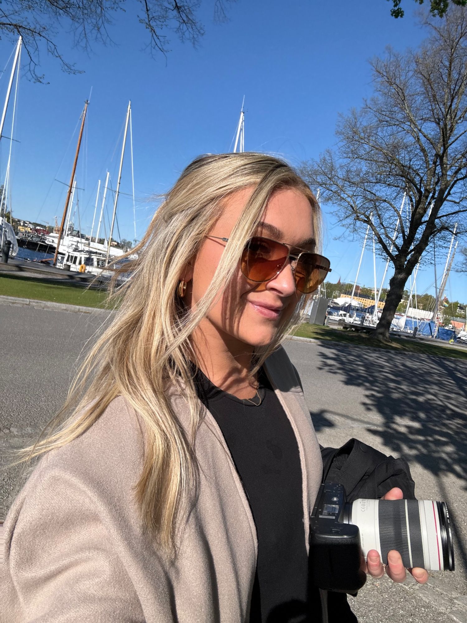 Casual outdoor photos taken near a marina showing blonde hair and sunglasses on a sunny day.