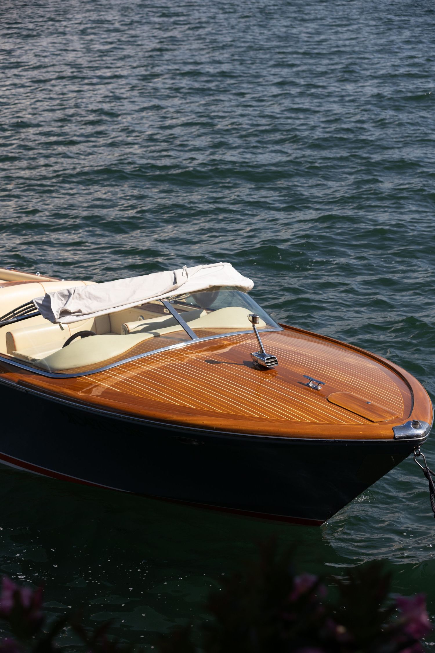 Close-up of polished wooden Riva boat deck showing classic craftsmanship and luxury details.