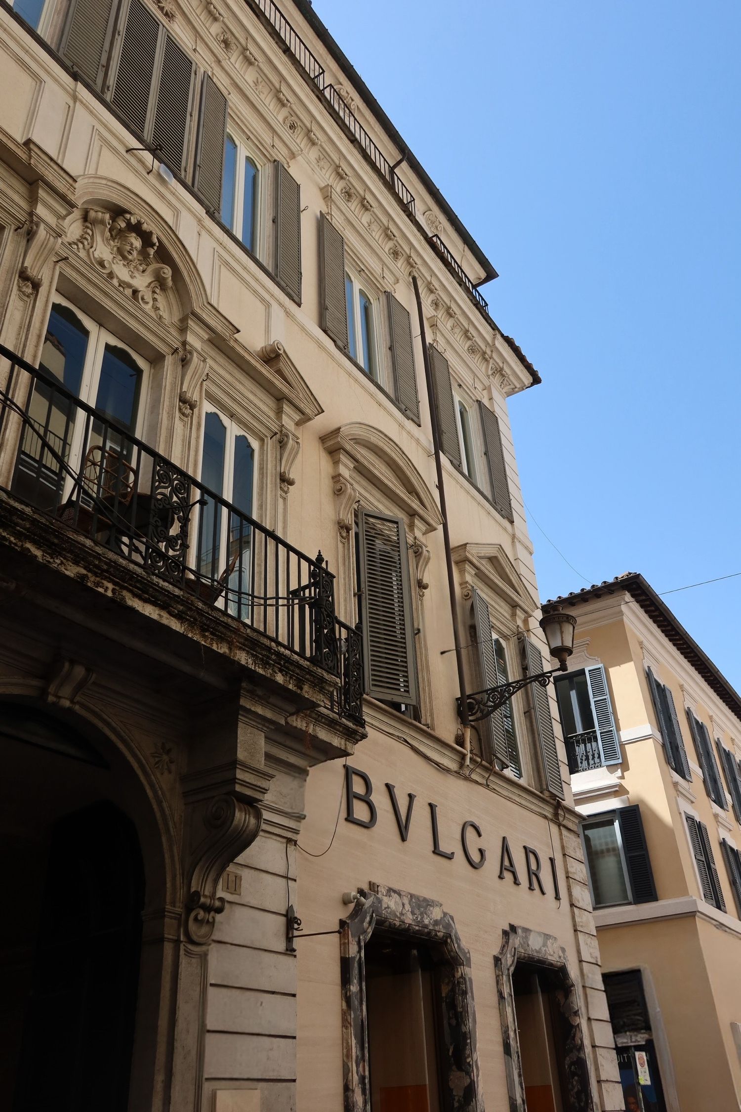 Elegant classical building facade with Bulgari signage and ornate architectural details.