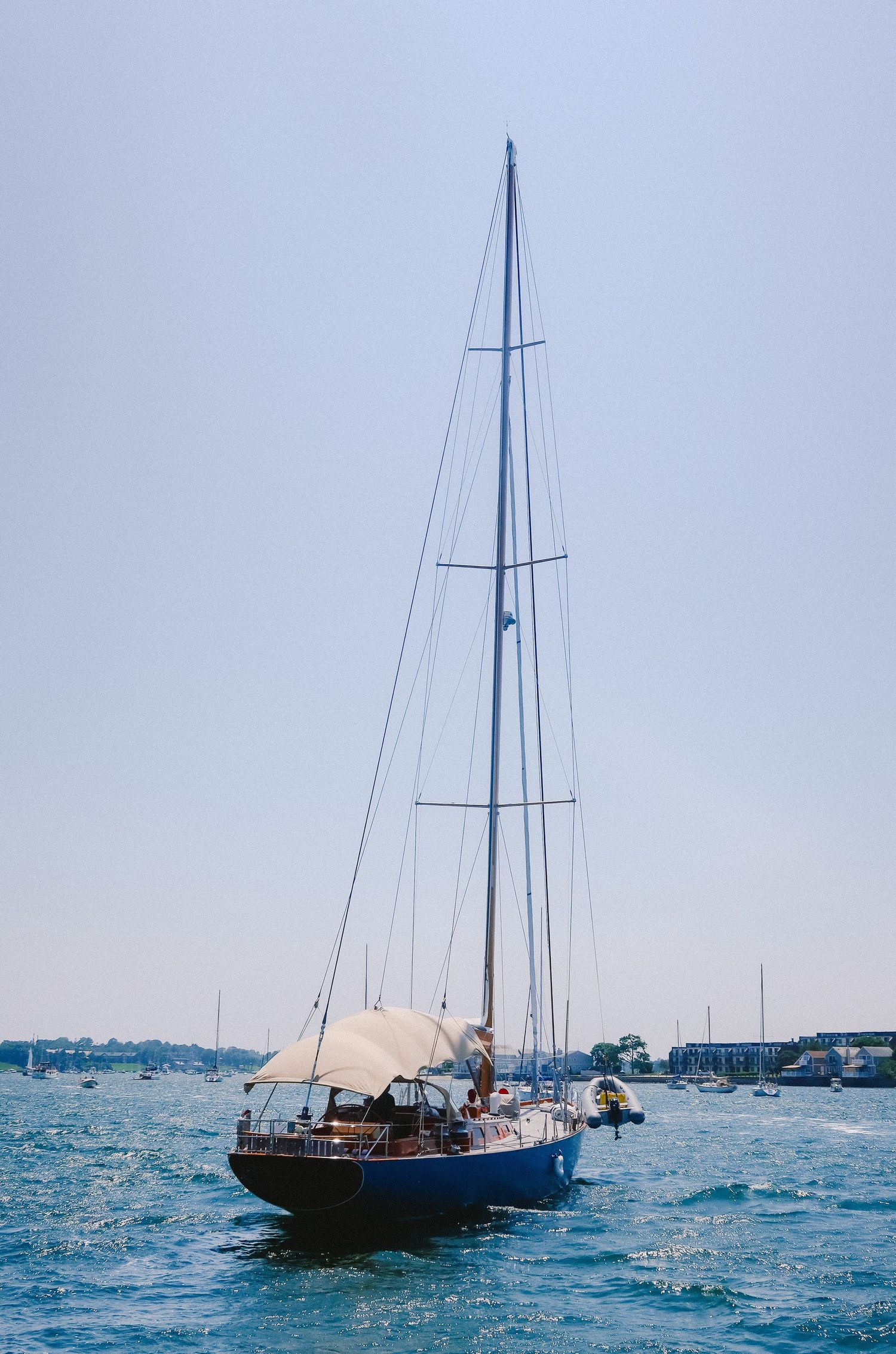 Classic sailing yacht with tall masts anchored in a blue harbor.