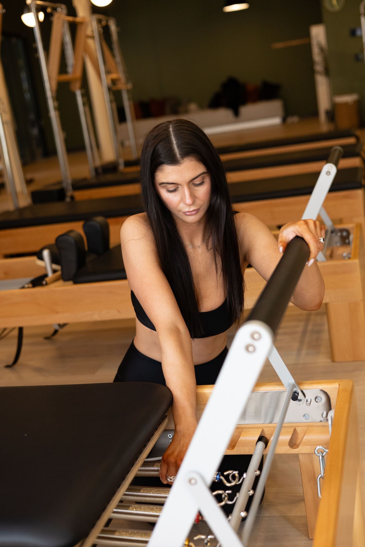 Detailed view of proper hand positioning on Pilates reformer carriage during exercise.