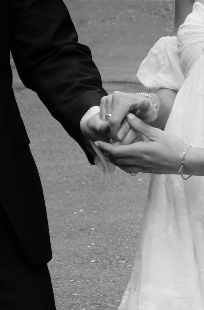 Close-up of hands clasped together in a dancing pose against a dark background.