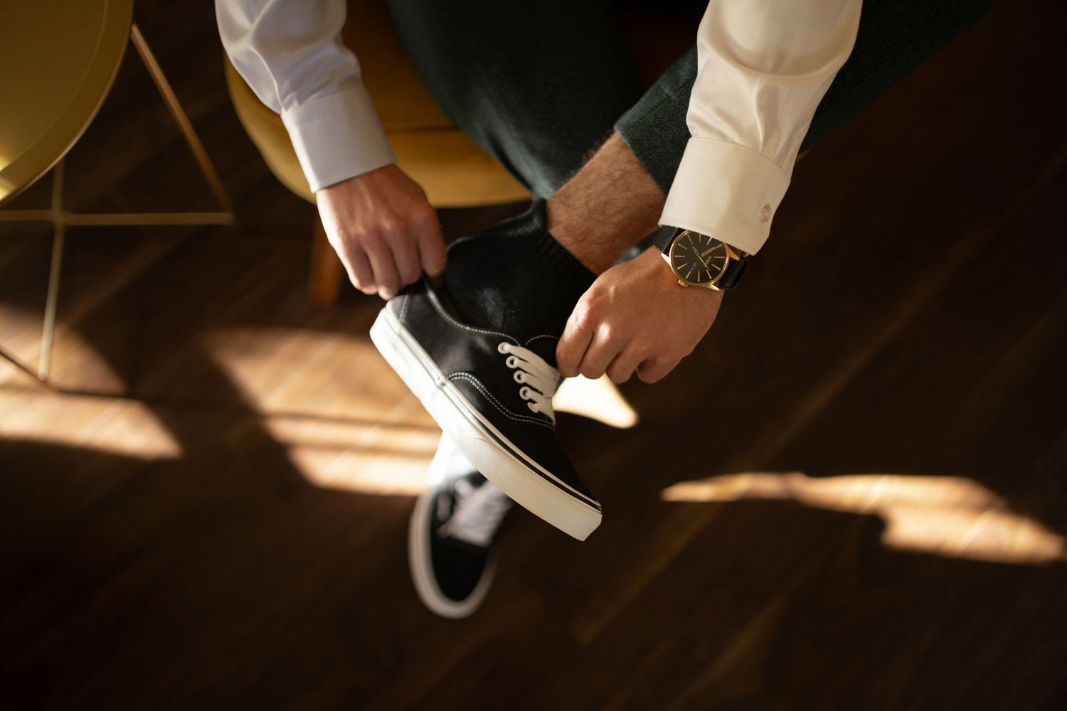 Detail shot of formal shoes in dramatic sunlight on dark wooden floor.
