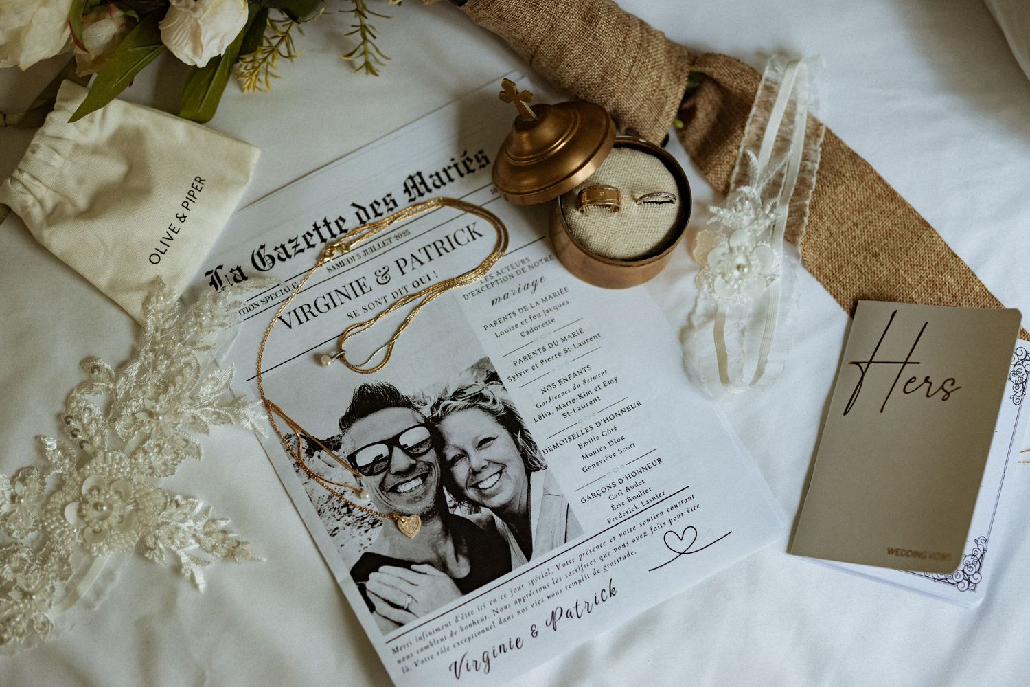 Wedding invitation details and decorative elements arranged on a textured surface.