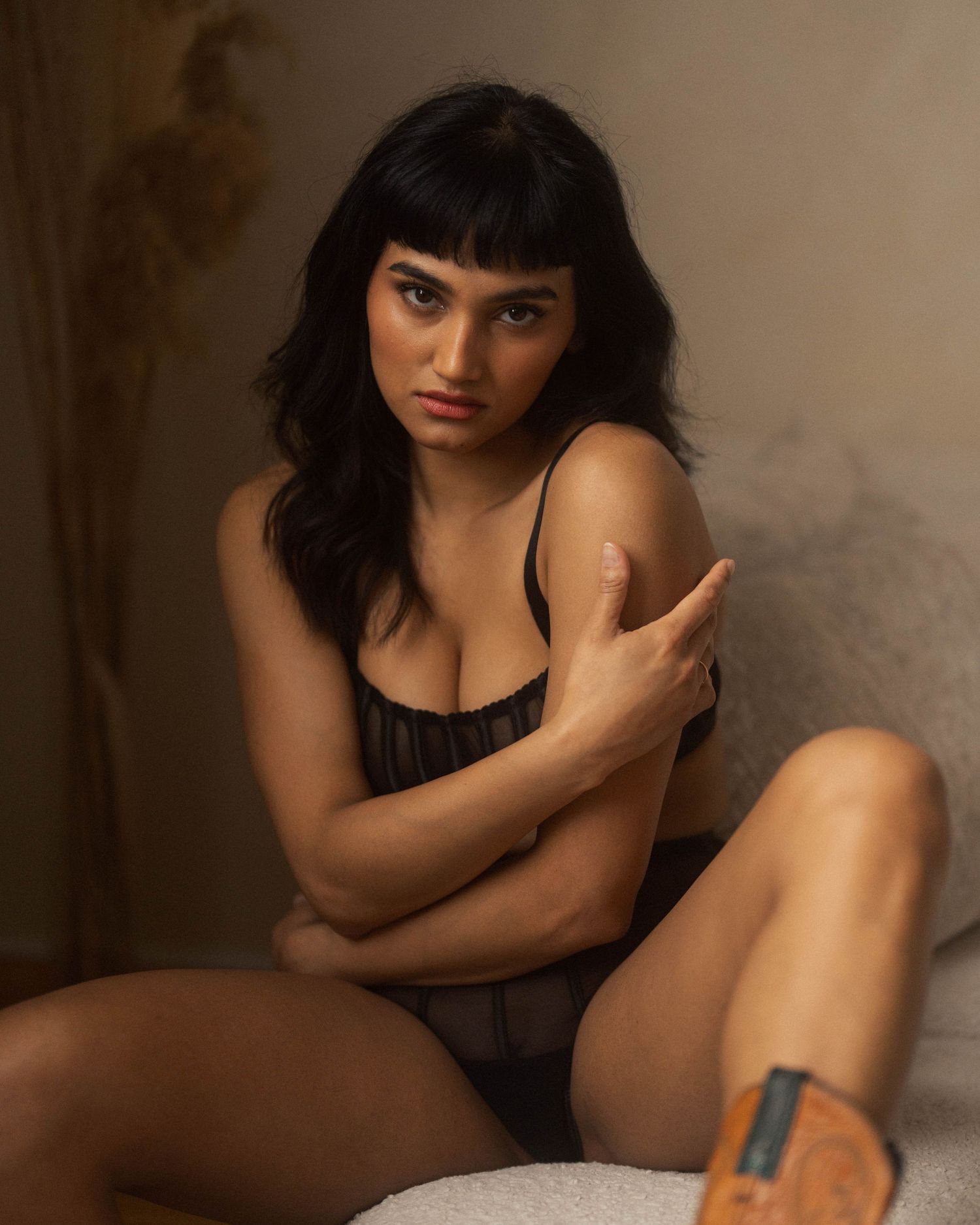 Sensual boudoir photograph with natural lighting and soft tones.