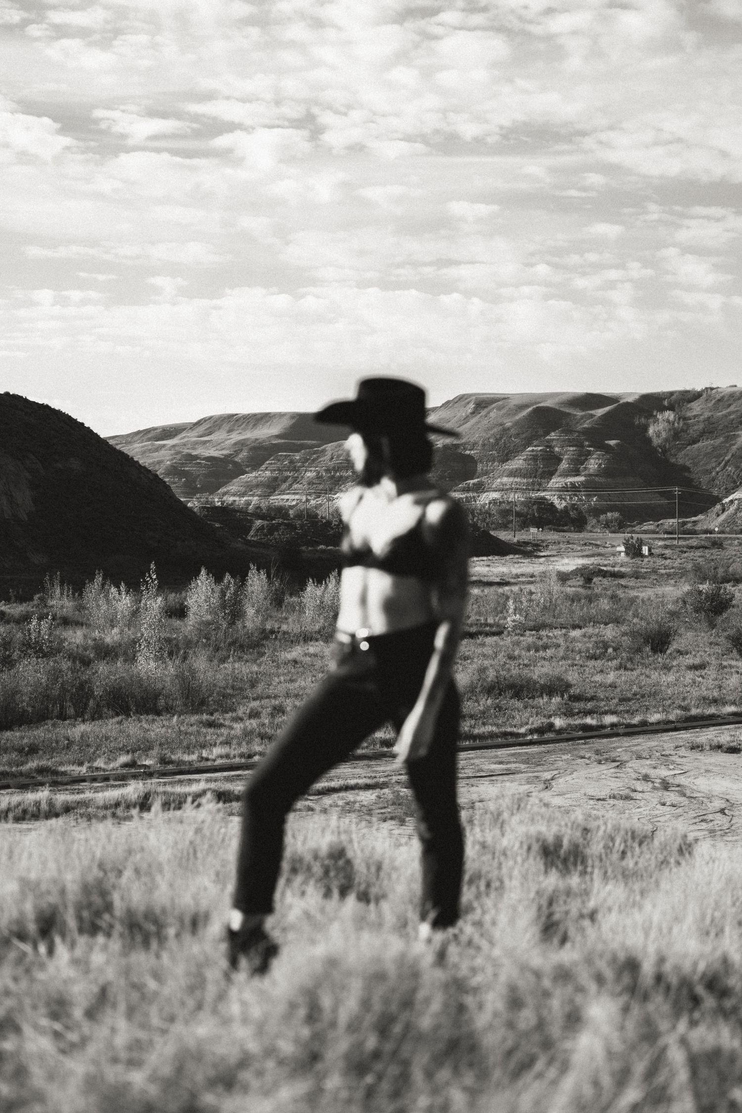 Black and white landscape photo showing a silhouetted figure in motion against mountain scenery.