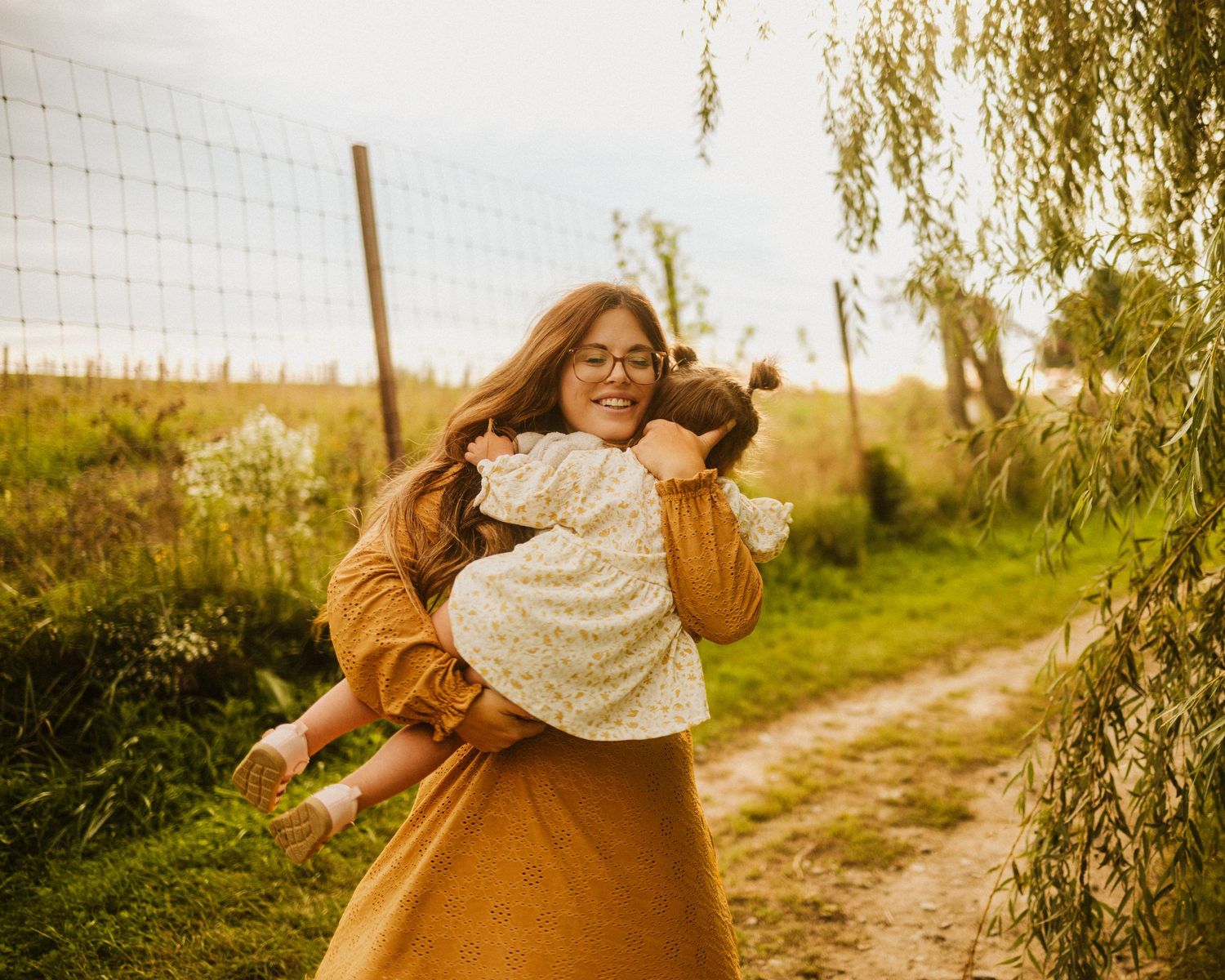 Golden hour photographs of a person in a white sweater and brown dress walking outdoors.