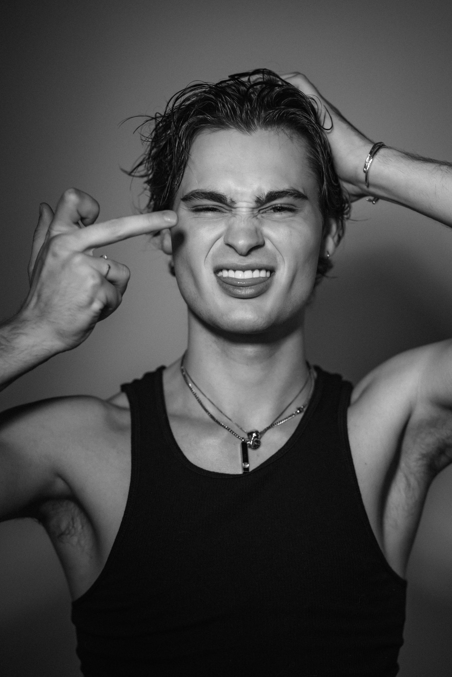 Expressive black and white portraits showing playful poses in tank top.