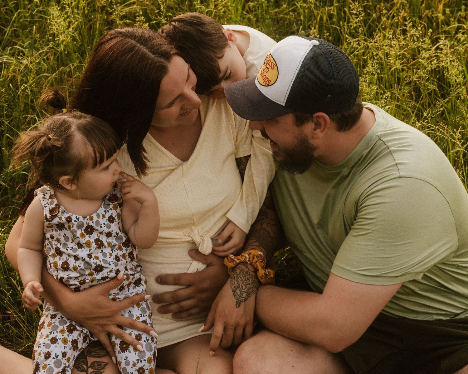 Family sharing tender moments together in flowering meadow at sunset.