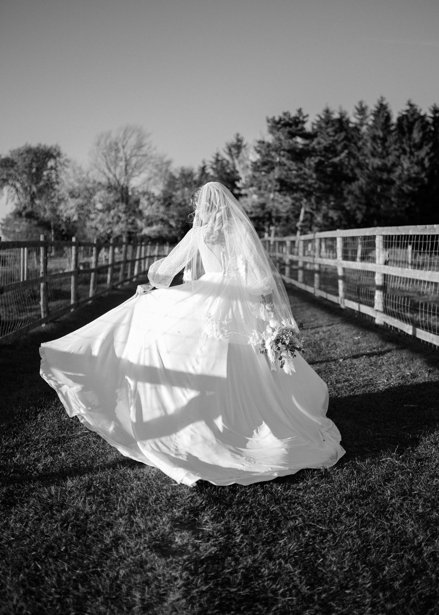 A dramatic black and white series showing a billowing wedding dress in an outdoor setting.