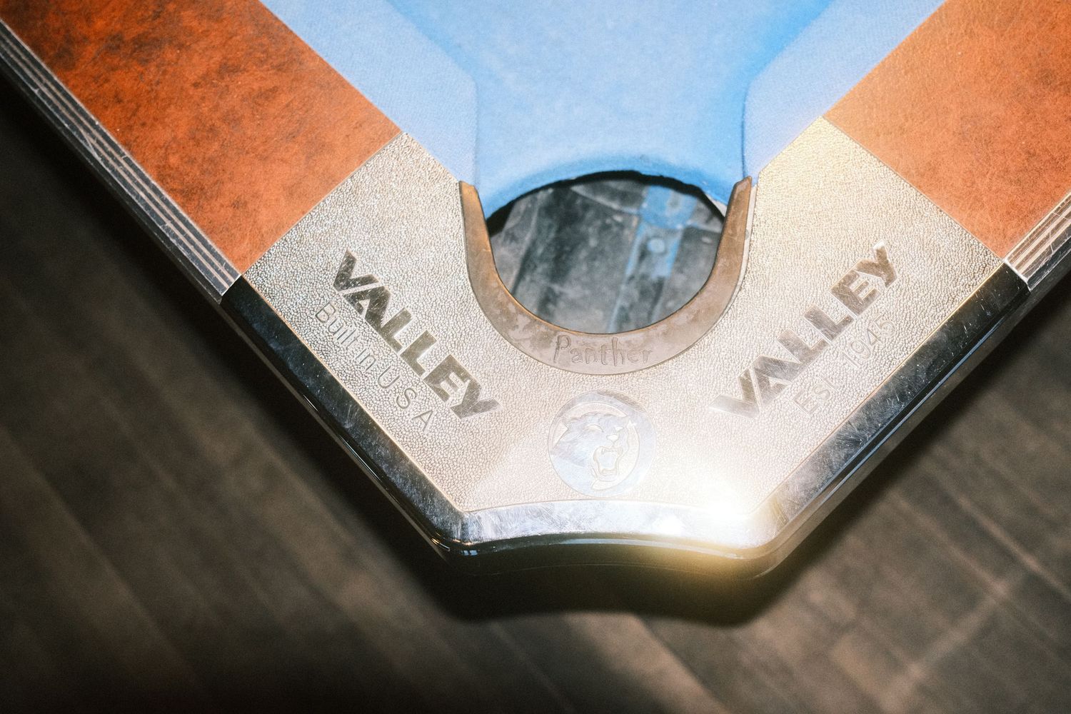 Close-up of a Valley brand pool table corner pocket with blue felt and brown rail detail.