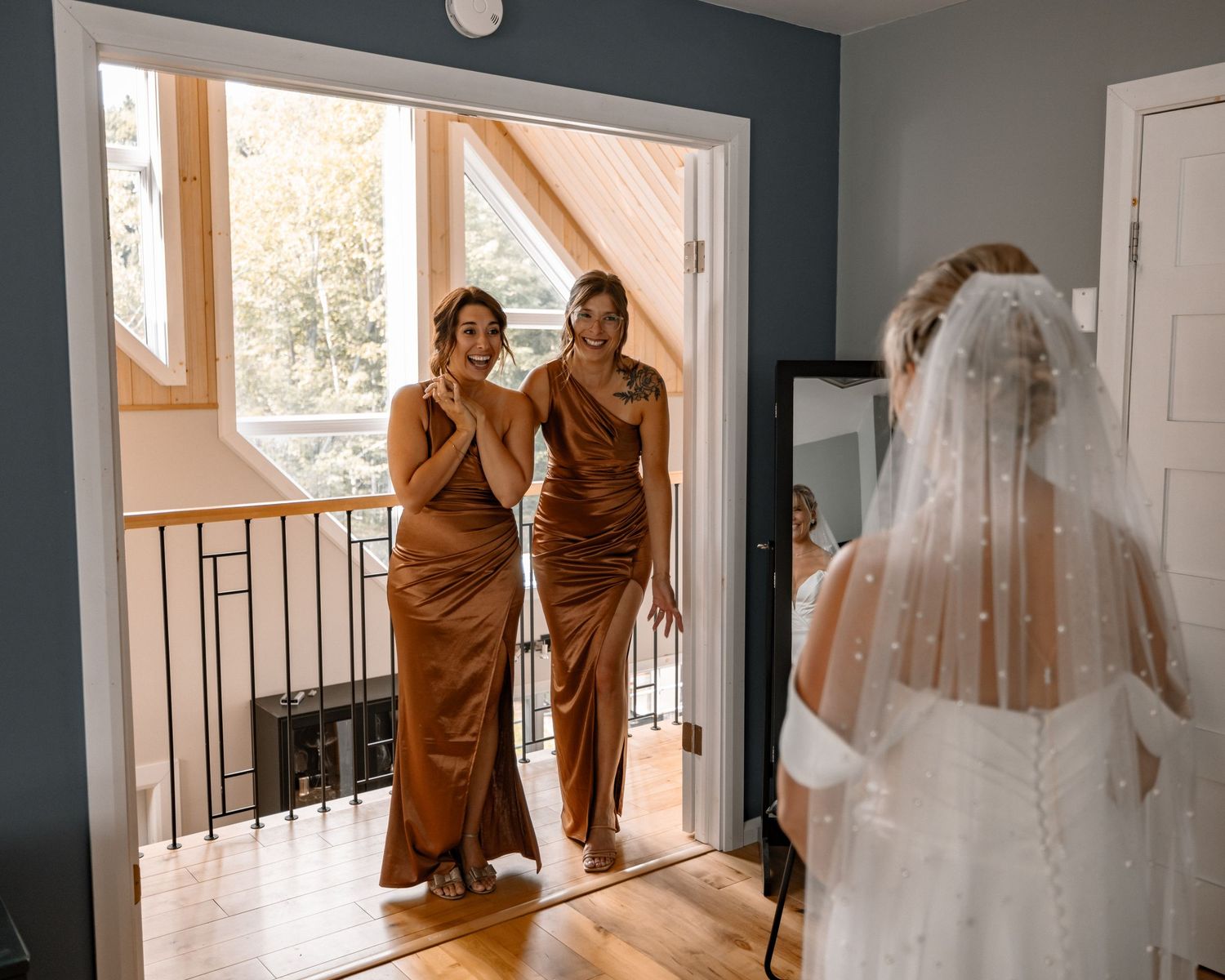 Wedding preparations in a room with large windows and flowing white dress.