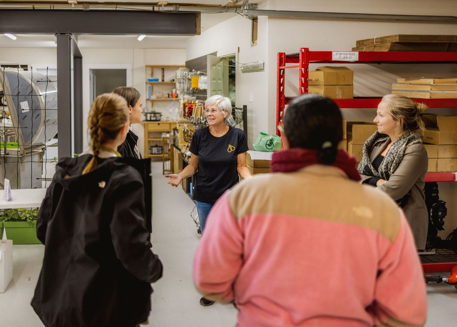 People walking through an industrial warehouse space with storage shelves.