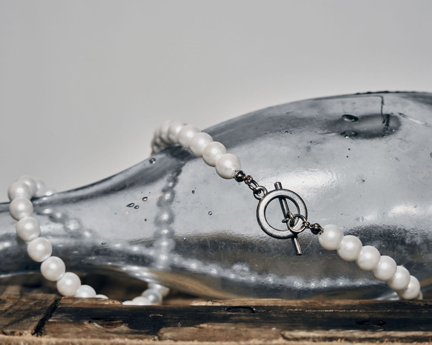 A close-up view of pearl necklaces arranged on a gray textured surface.