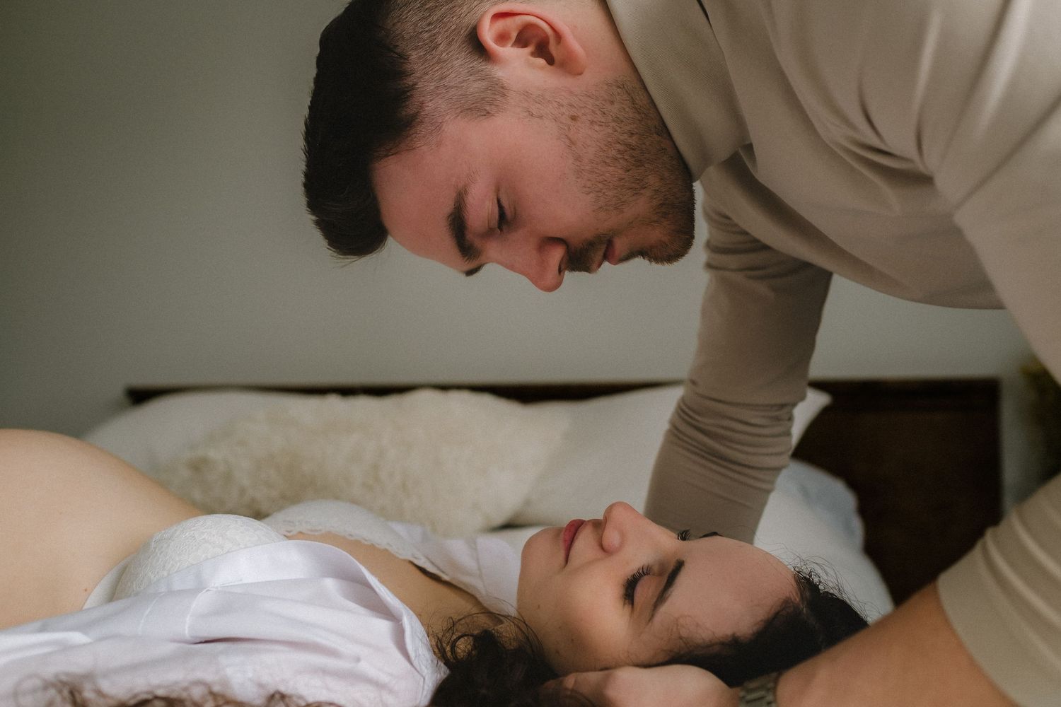Romantic couple sharing intimate moments together on a bed.