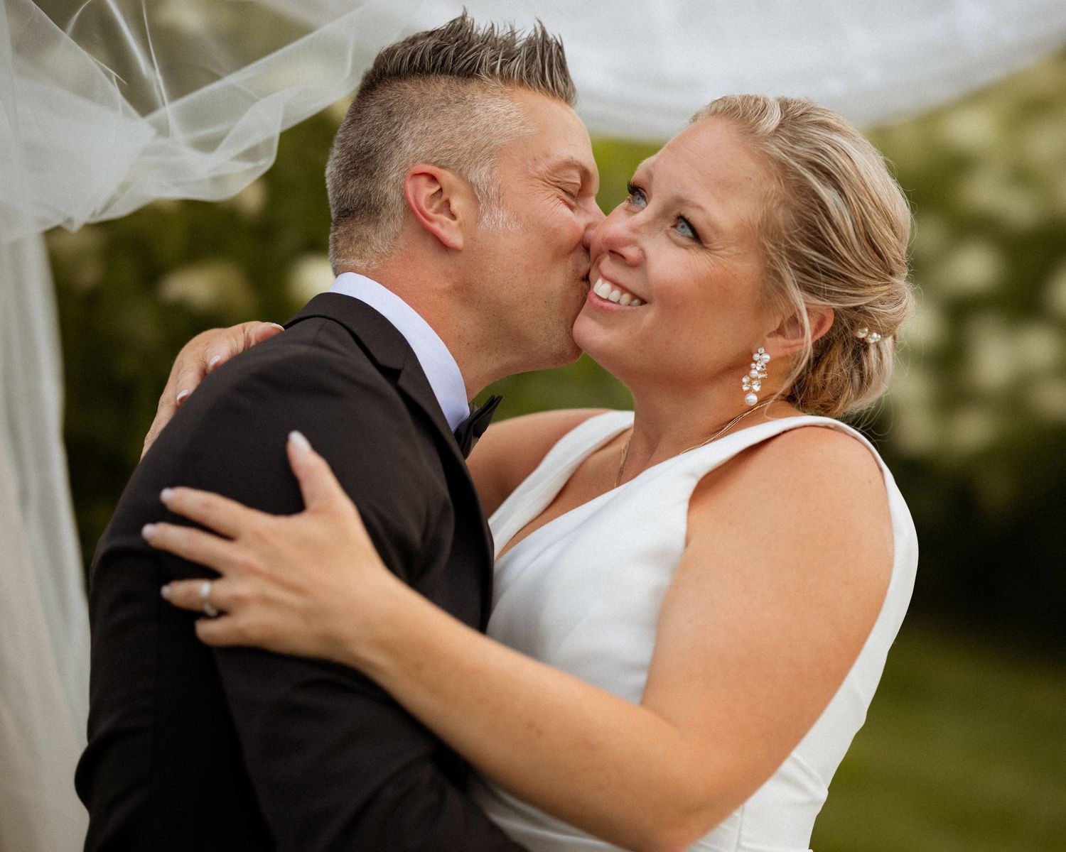 Wedding couple embraces during outdoor portrait session.