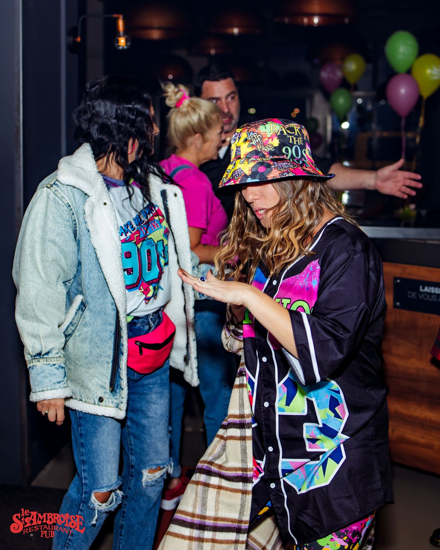 People dancing in colorful 90s style clothing at a retro party.