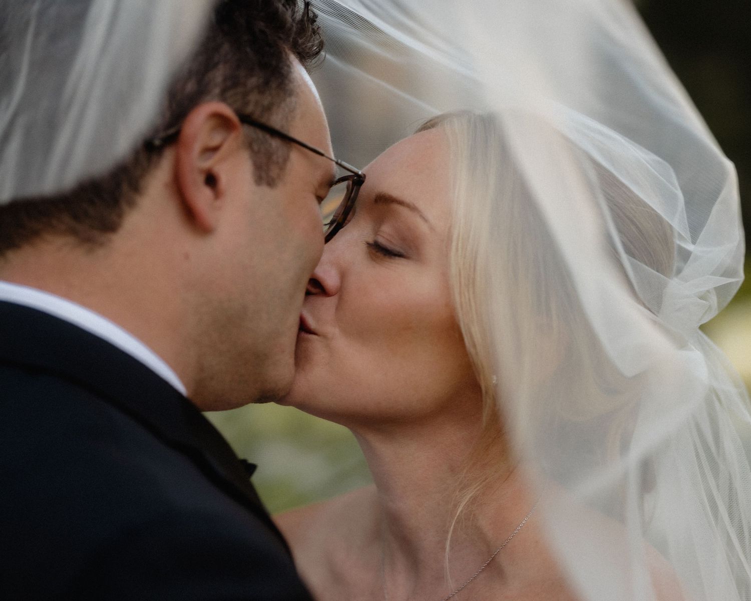 Intimate wedding portrait with flowing veil creating romantic atmosphere.