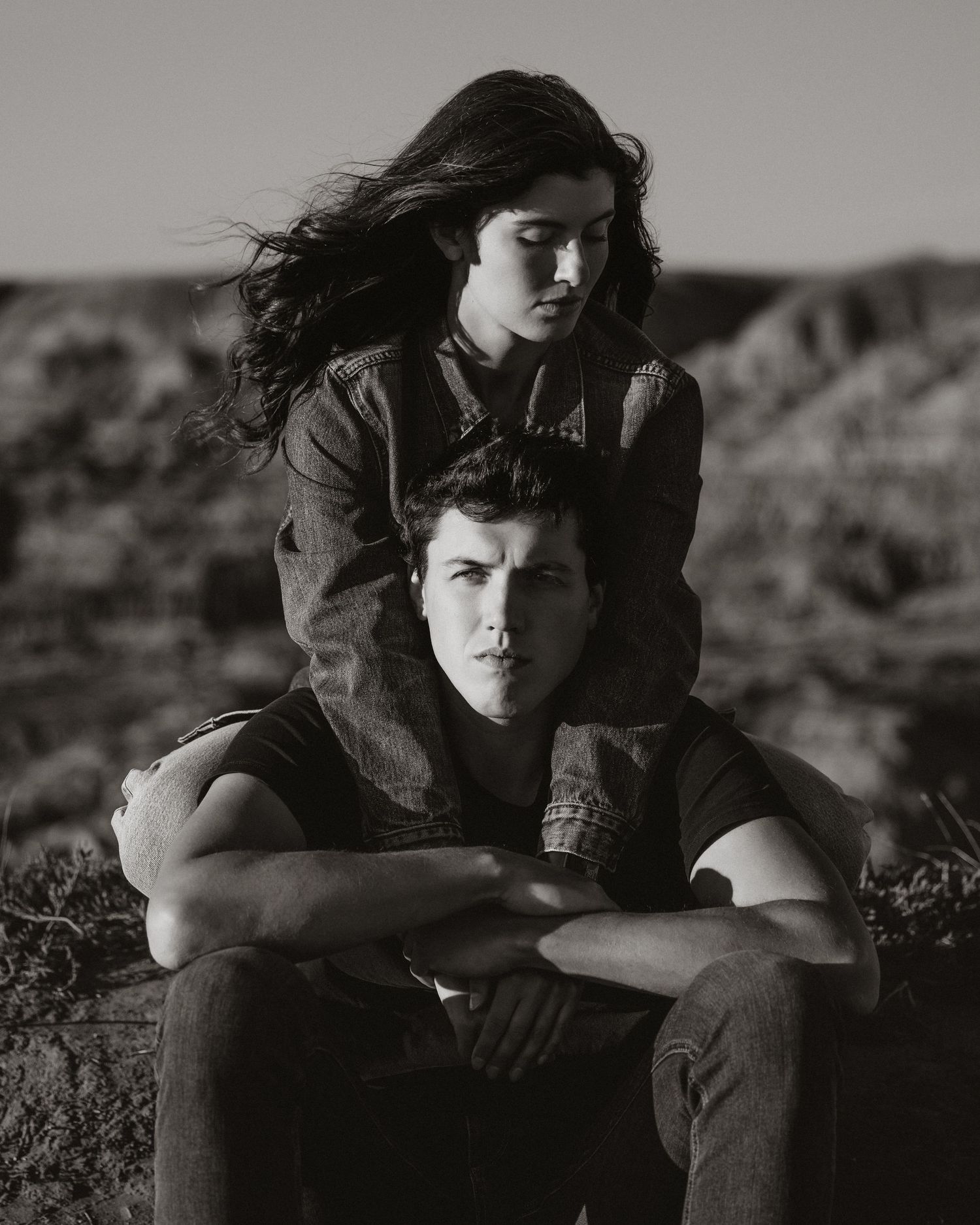 Artistic black and white portrait of couple in desert setting.