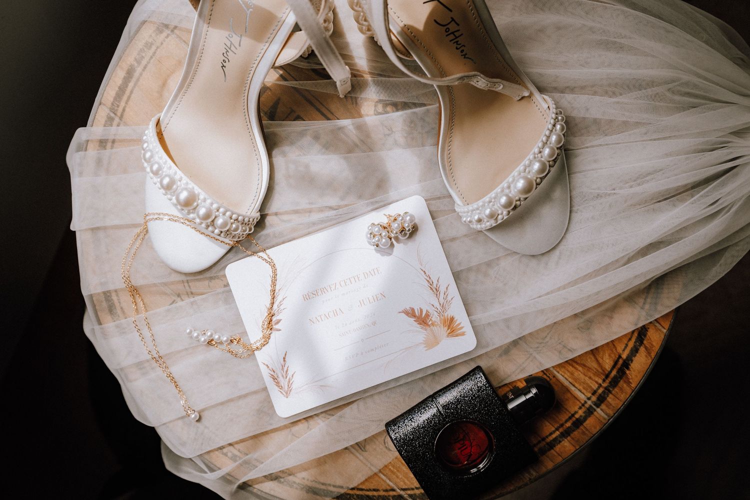 Wedding dress details and accessories arranged artistically on a dark background.