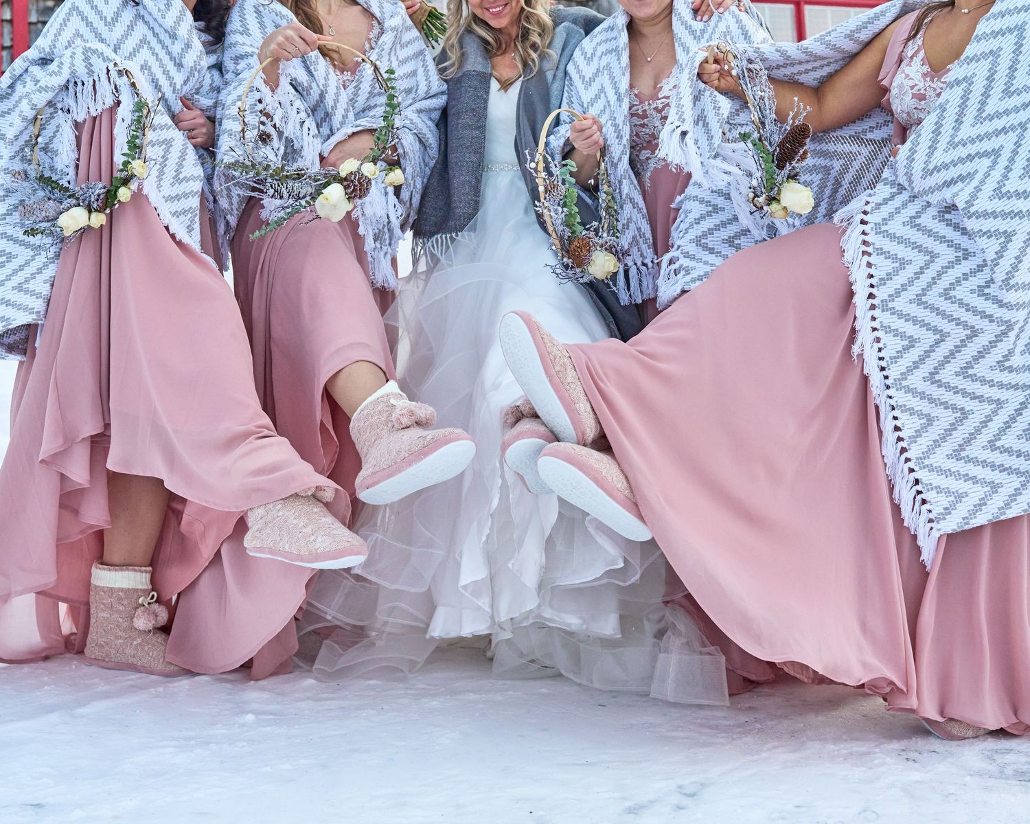 Wedding party members in pink and patterned attire pose together.