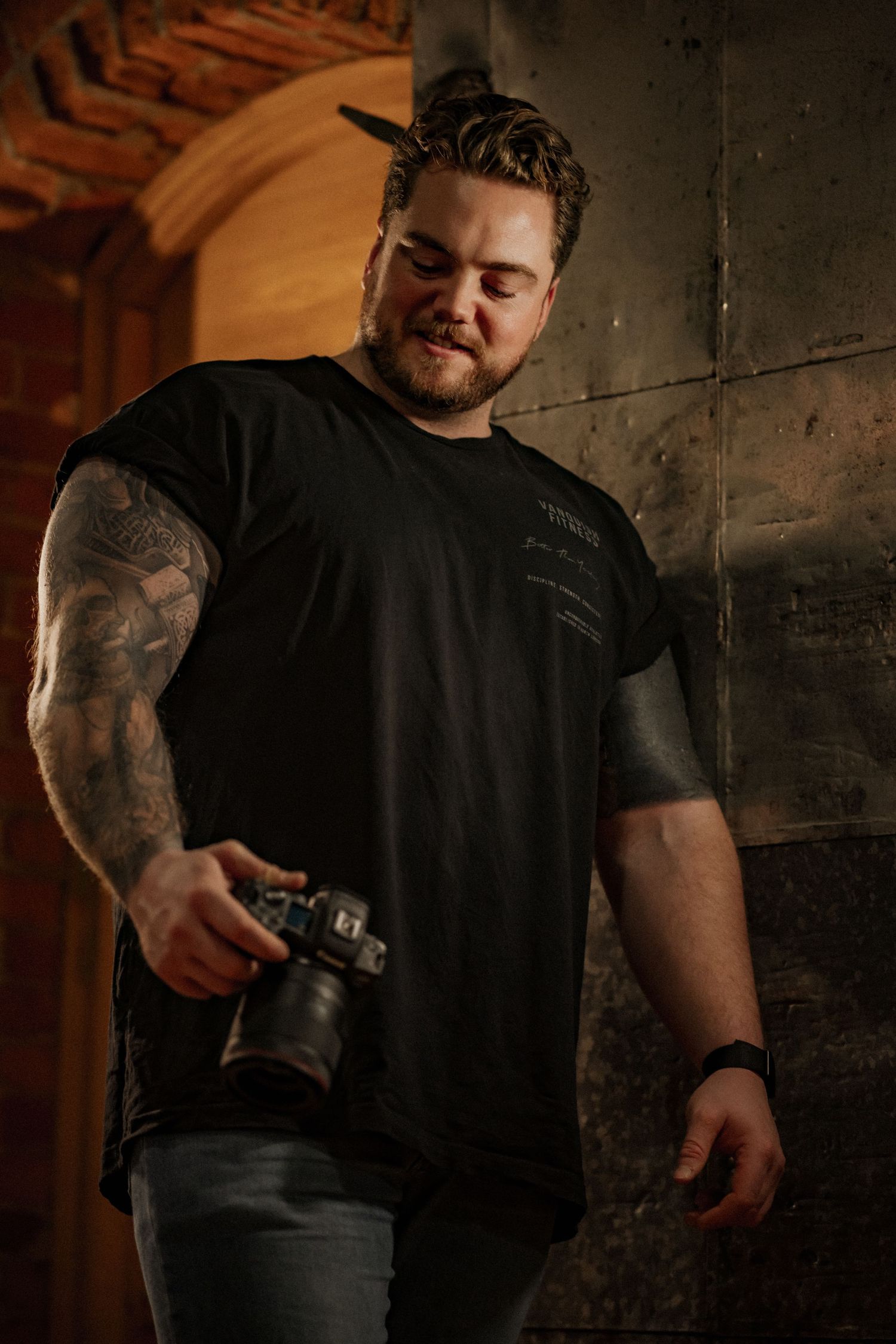 Tattooed person in black shirt shown in sequence of dramatic poses against dark background.
